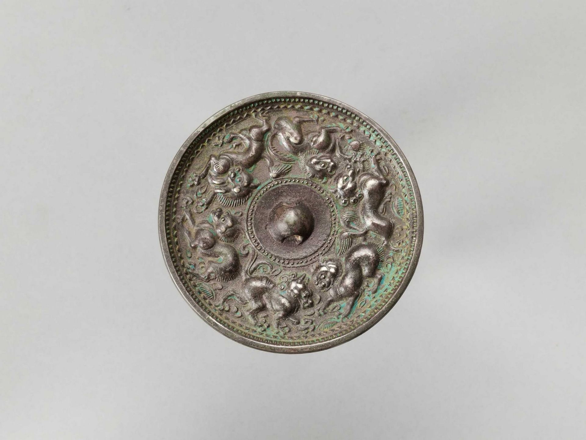 A CIRCULAR BRONZE MIRROR WITH ANIMALS