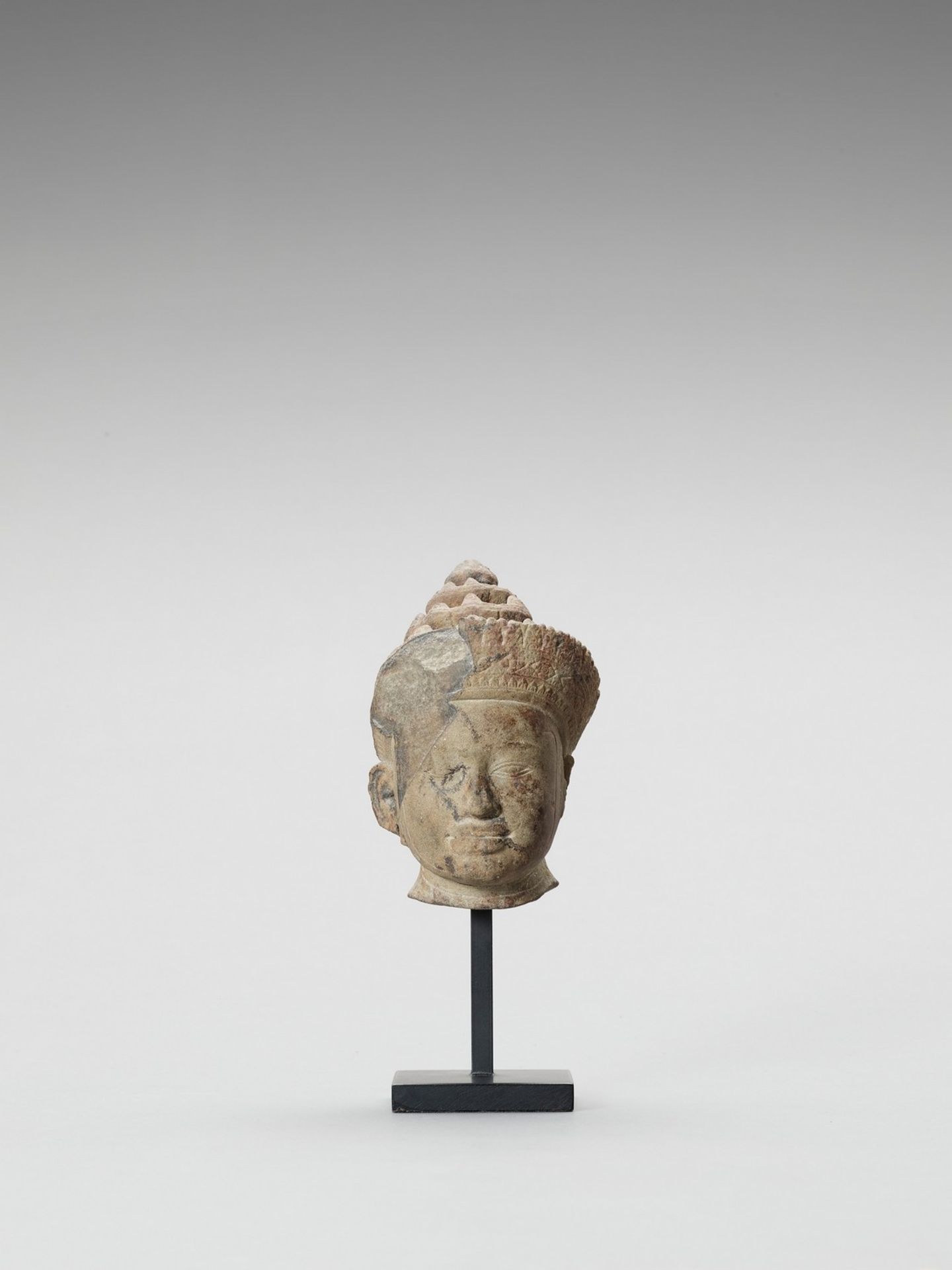 A KHMER SANDSTONE HEAD OF VISHNU, PRE RUP STYLE, LATER 10TH CENTURY