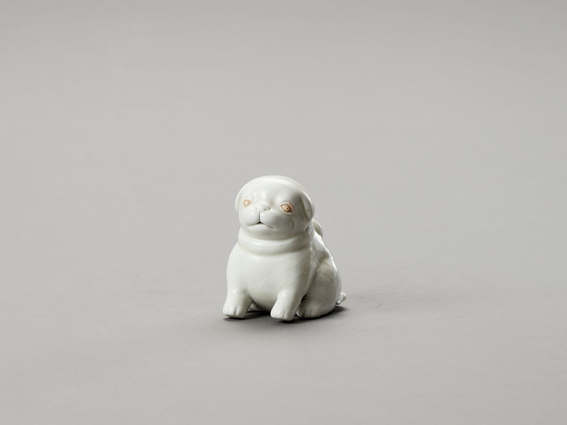 A WHITE HIRADO PORCELAIN FIGURE OF A PUPPY