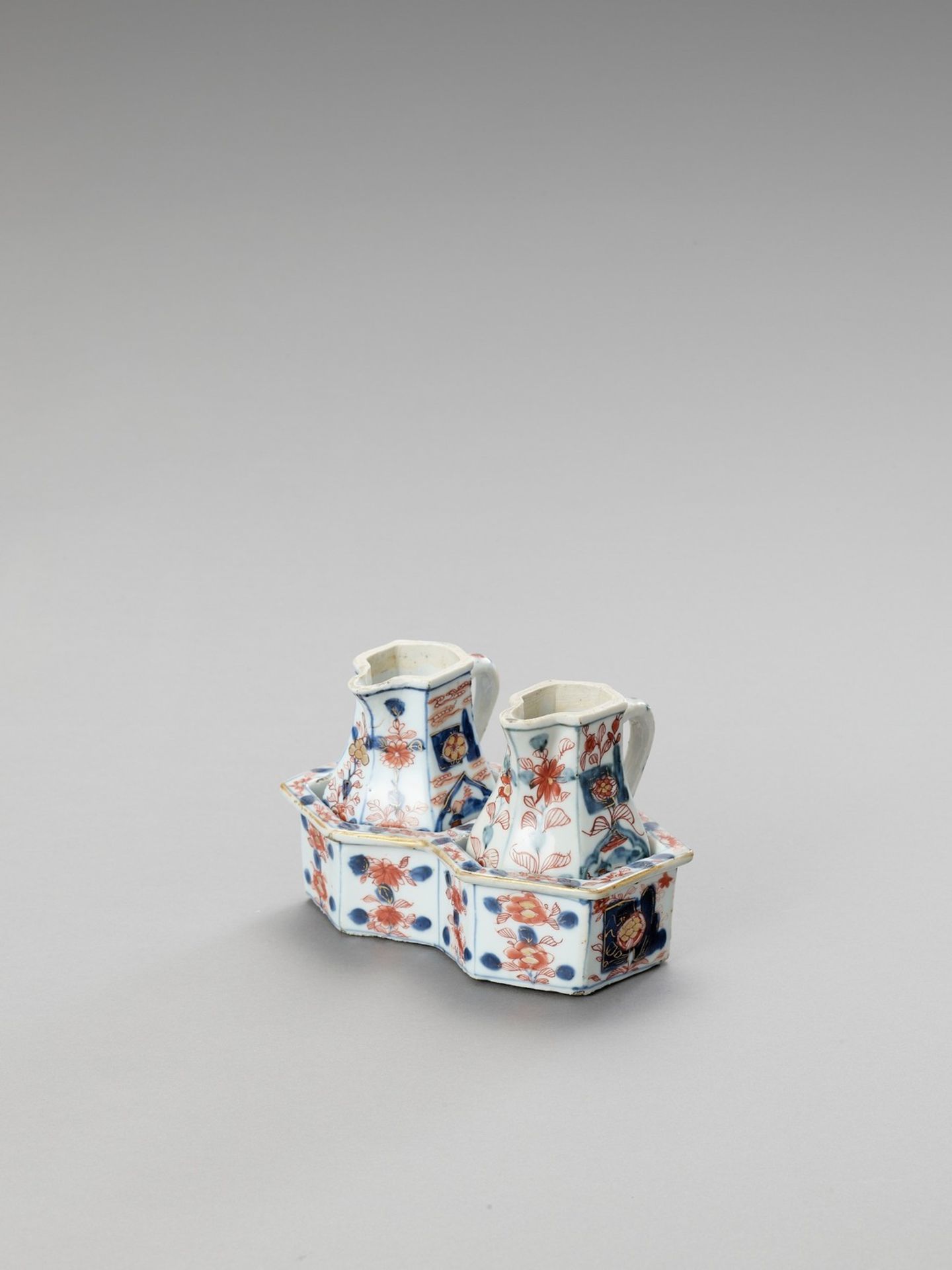 A PAIR OF IMARI PORCELAIN JUGS WITH ORIGINAL HOLDER