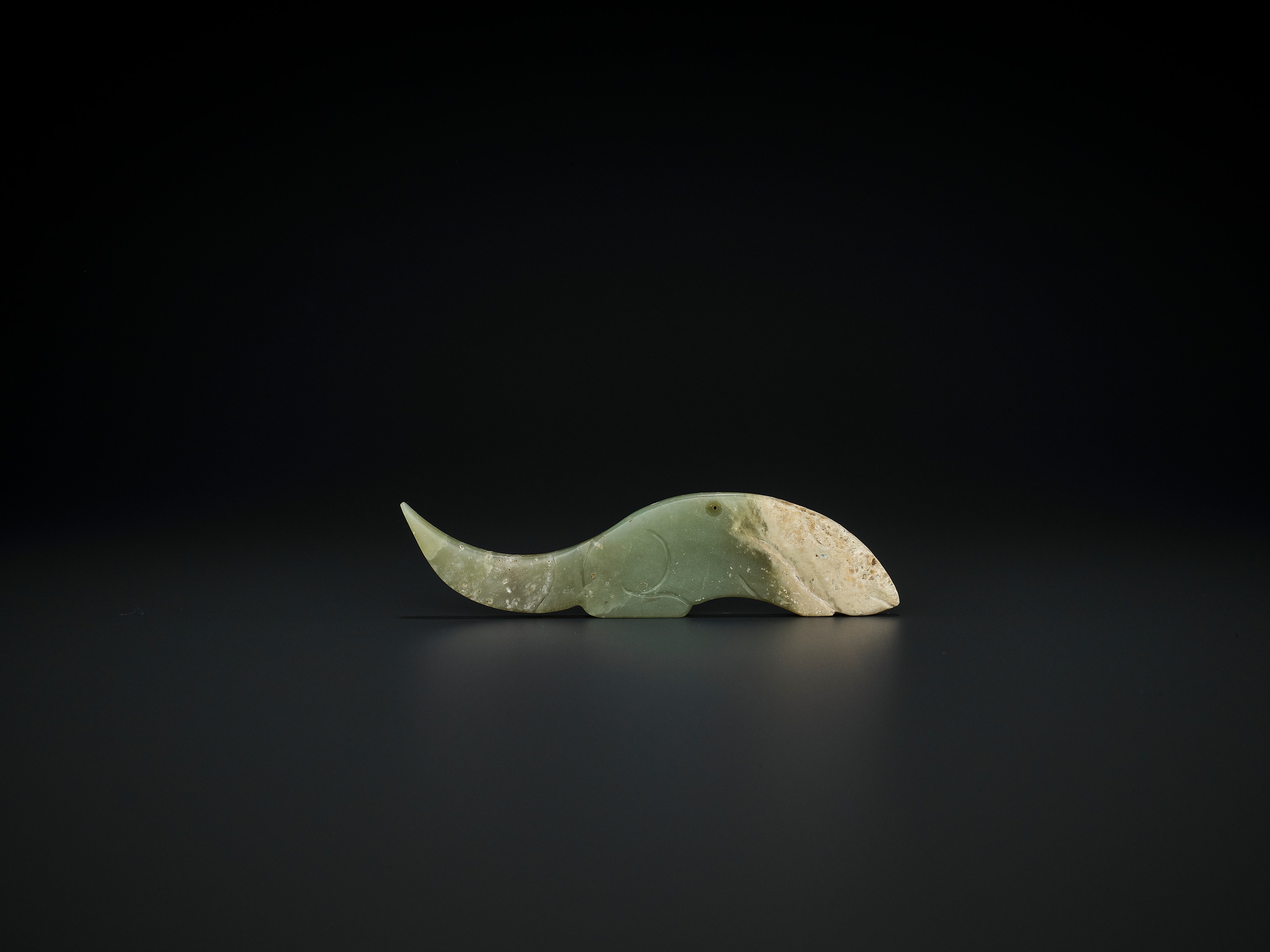 A CELADON JADE 'CROUCHING TIGER' PENDANT, WESTERN ZHOU DYNASTY