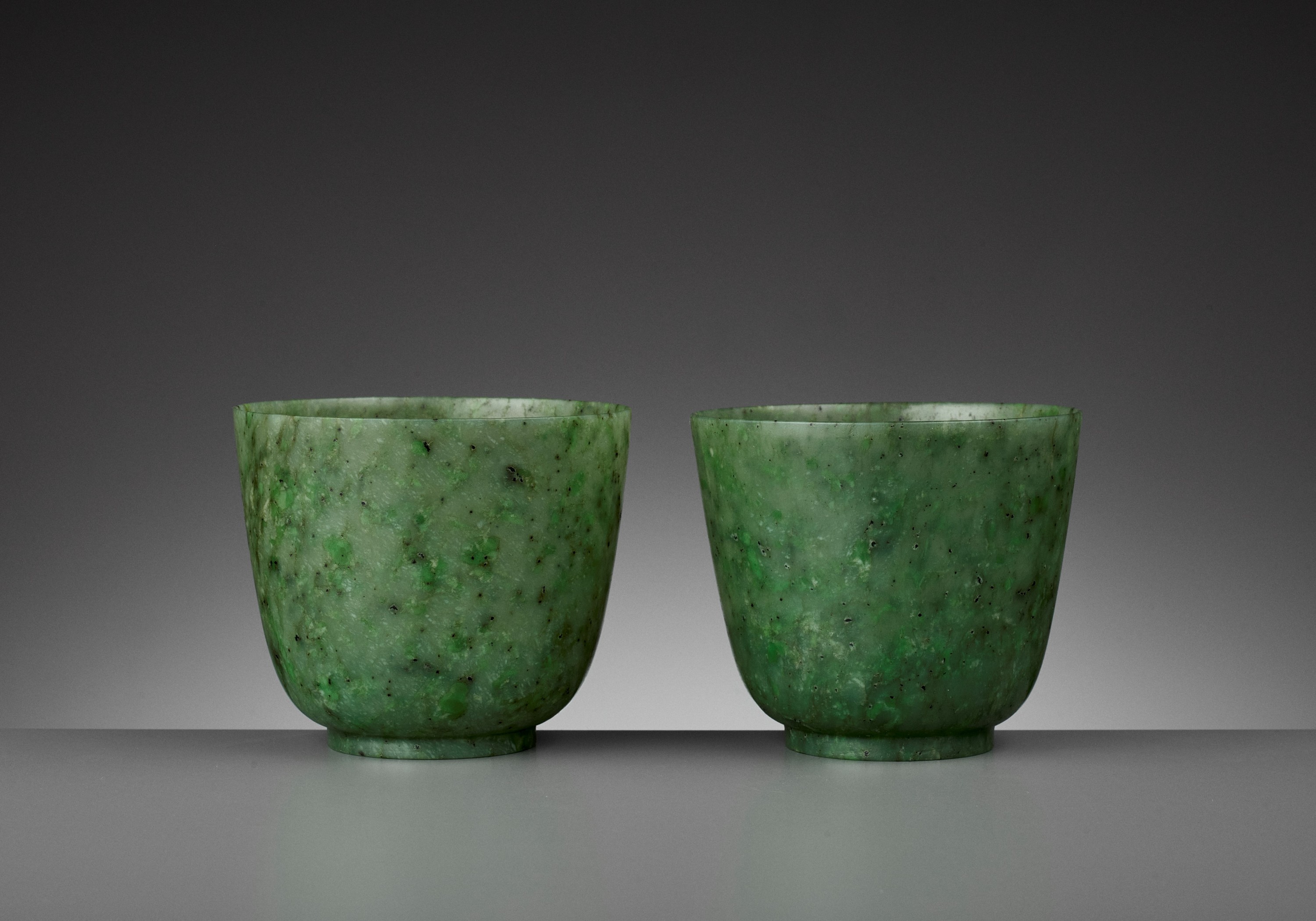 A PAIR OF SPINACH-GREEN JADE CUPS, QING DYNASTY