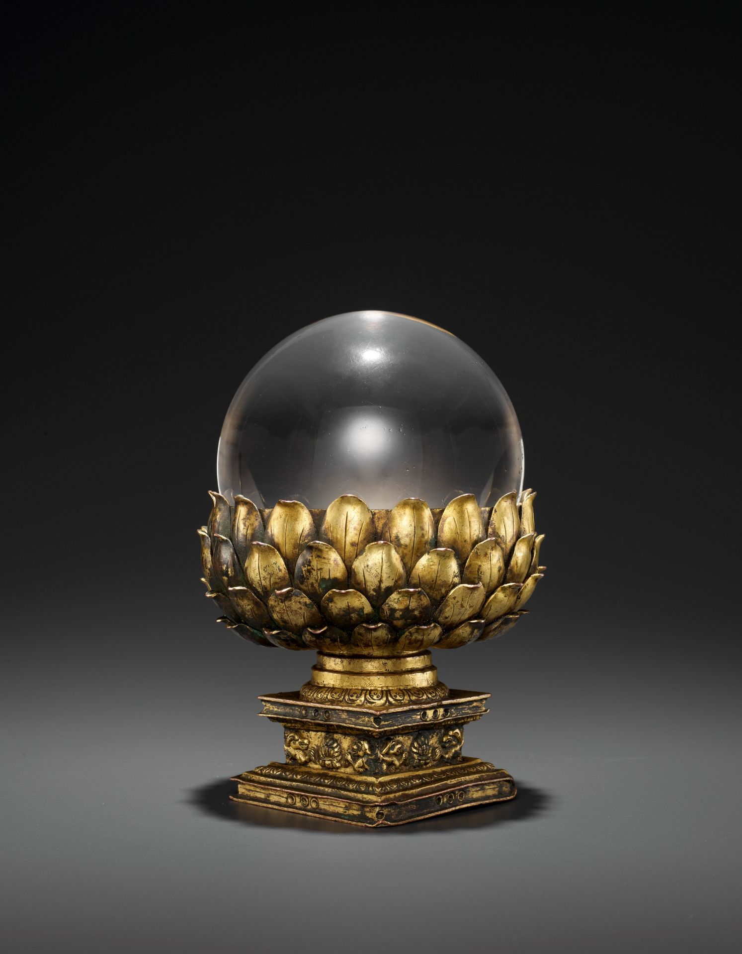 A ROCK CRYSTAL SPHERE WITH A GILT BRONZE LOTUS BASE, QING DYNASTY