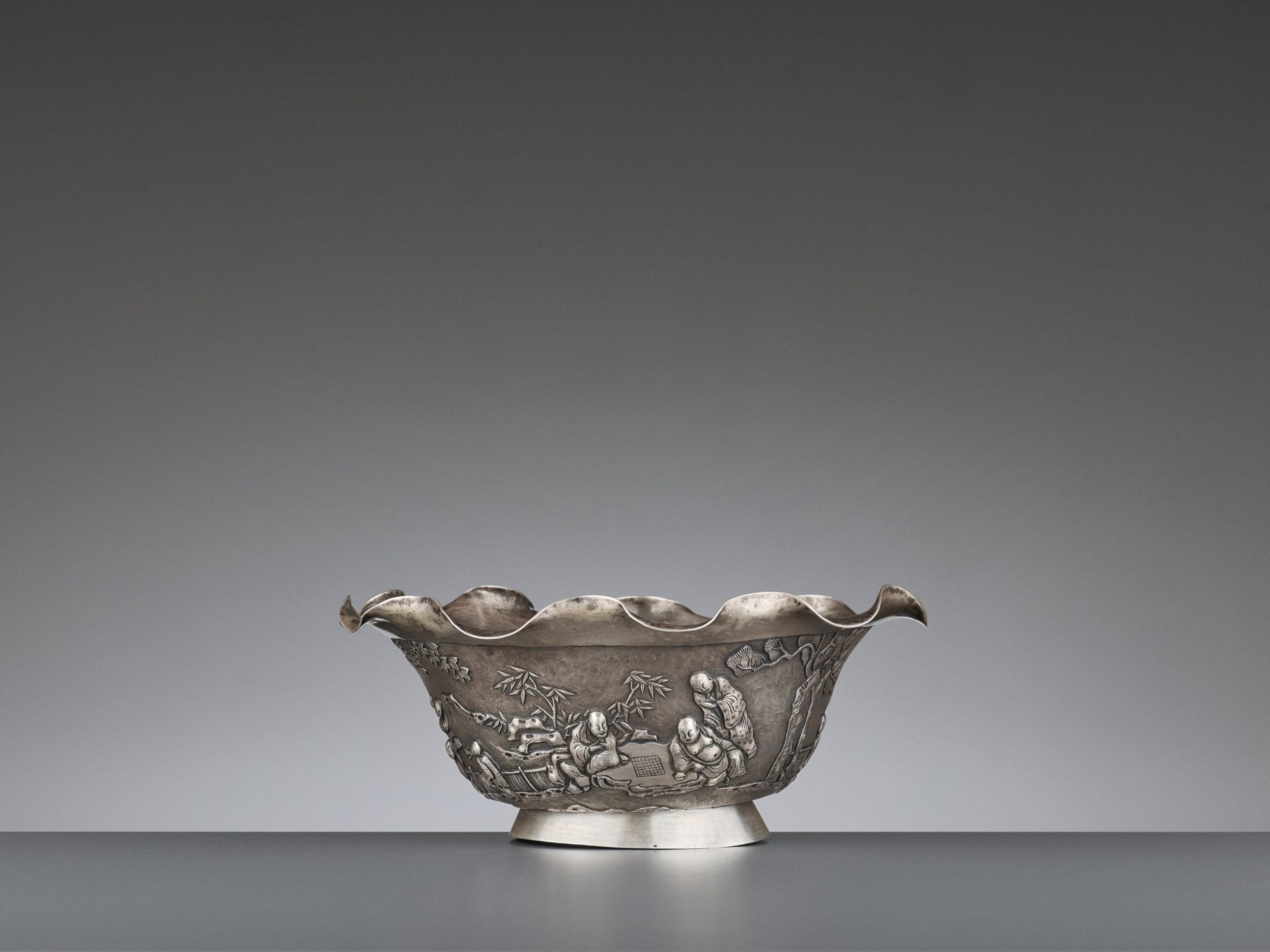 A SILVER REPOUSSE 'WEIQI PLAYERS' BOWL BY KWONG MAN SHING