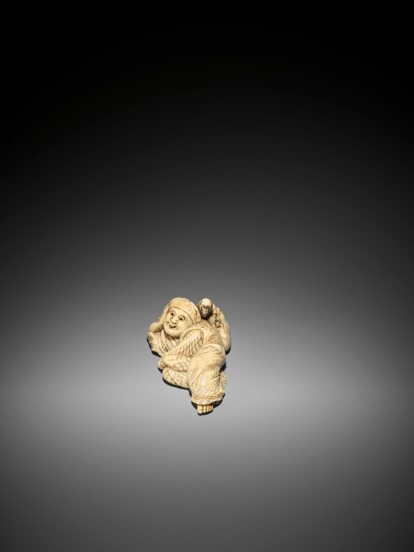 YOSHINAGA: A LARGE AND EXCEPTIONAL IVORY NETSUKE OF A RECLINING SARUMAWASHI WITH MONKEY - Image 5 of 9