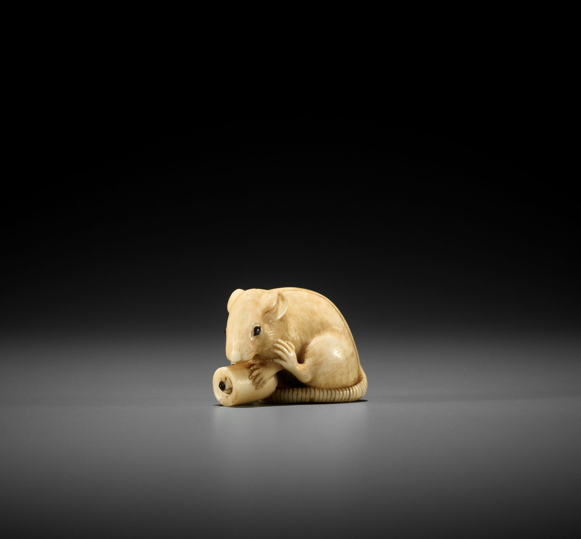 OKATOMO: A FINE IVORY NETSUKE OF A RAT WITH CANDLE