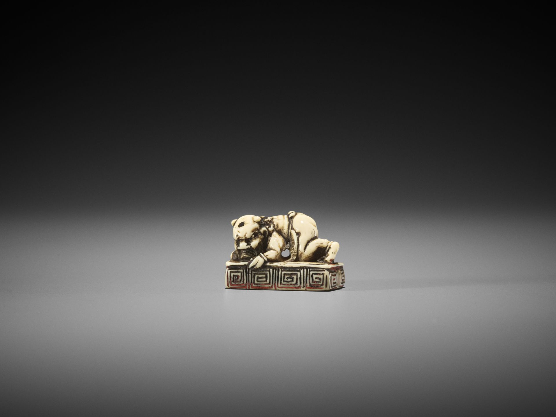 A RARE IVORY SEAL NETSUKE WITH AN ONI