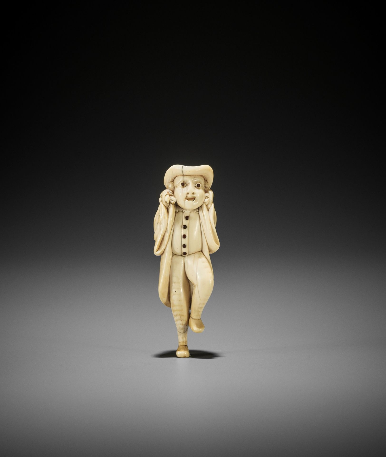 A SUPERB IVORY NETSUKE OF A DUTCHMAN WITH DEER CARCASS