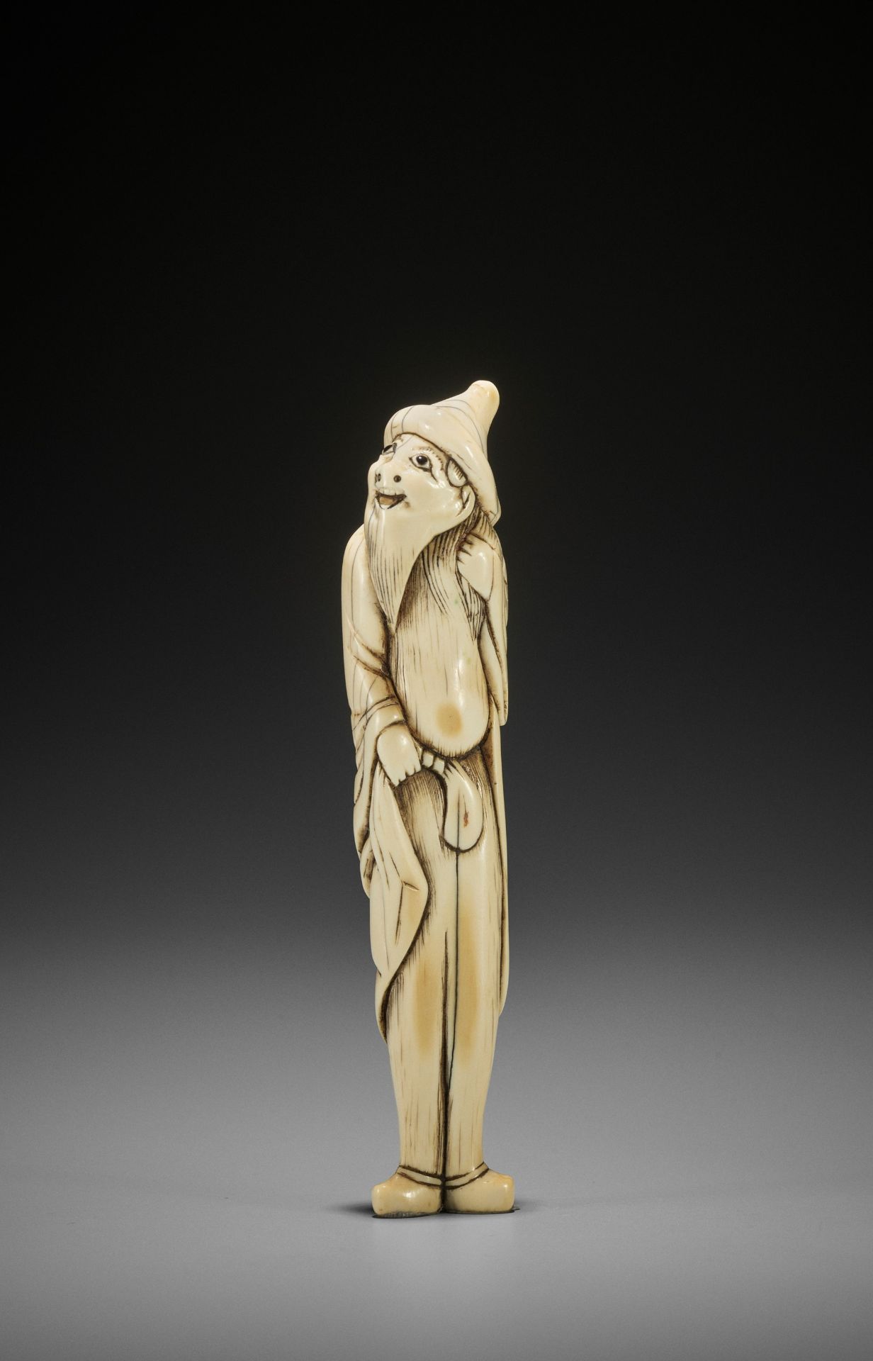 A RARE AND TALL IVORY NETSUKE OF A FOREIGNER