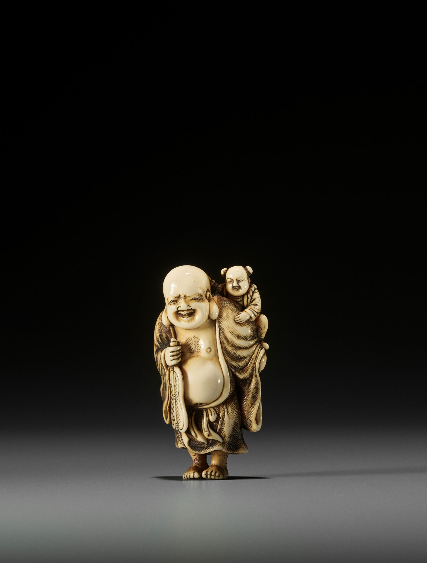 OKAKOTO: AN IVORY NETSUKE OF HOTEI WITH KARAKO