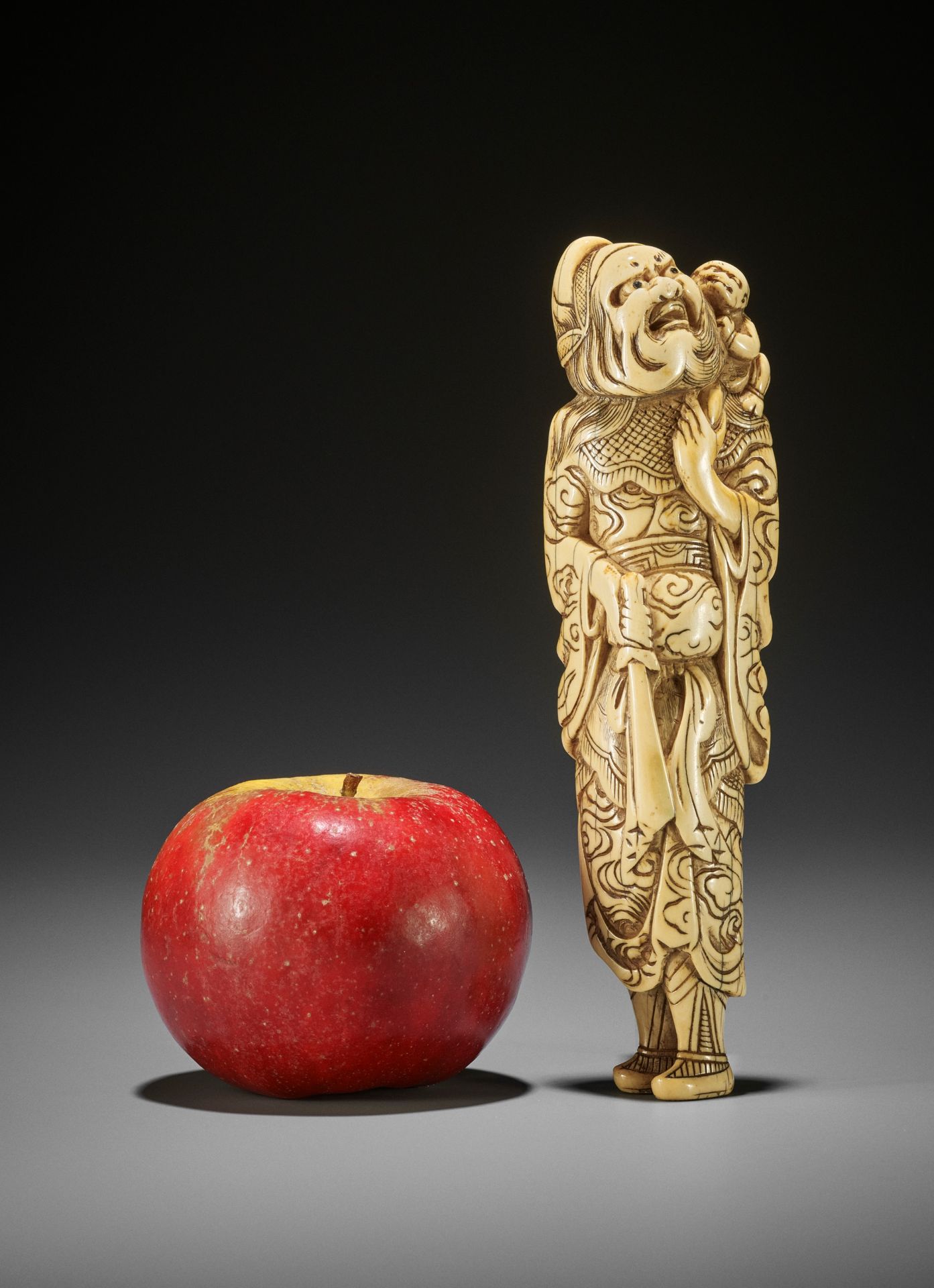 A MONUMENTALLY TALL IVORY NETSUKE OF SHOKI AND ONI