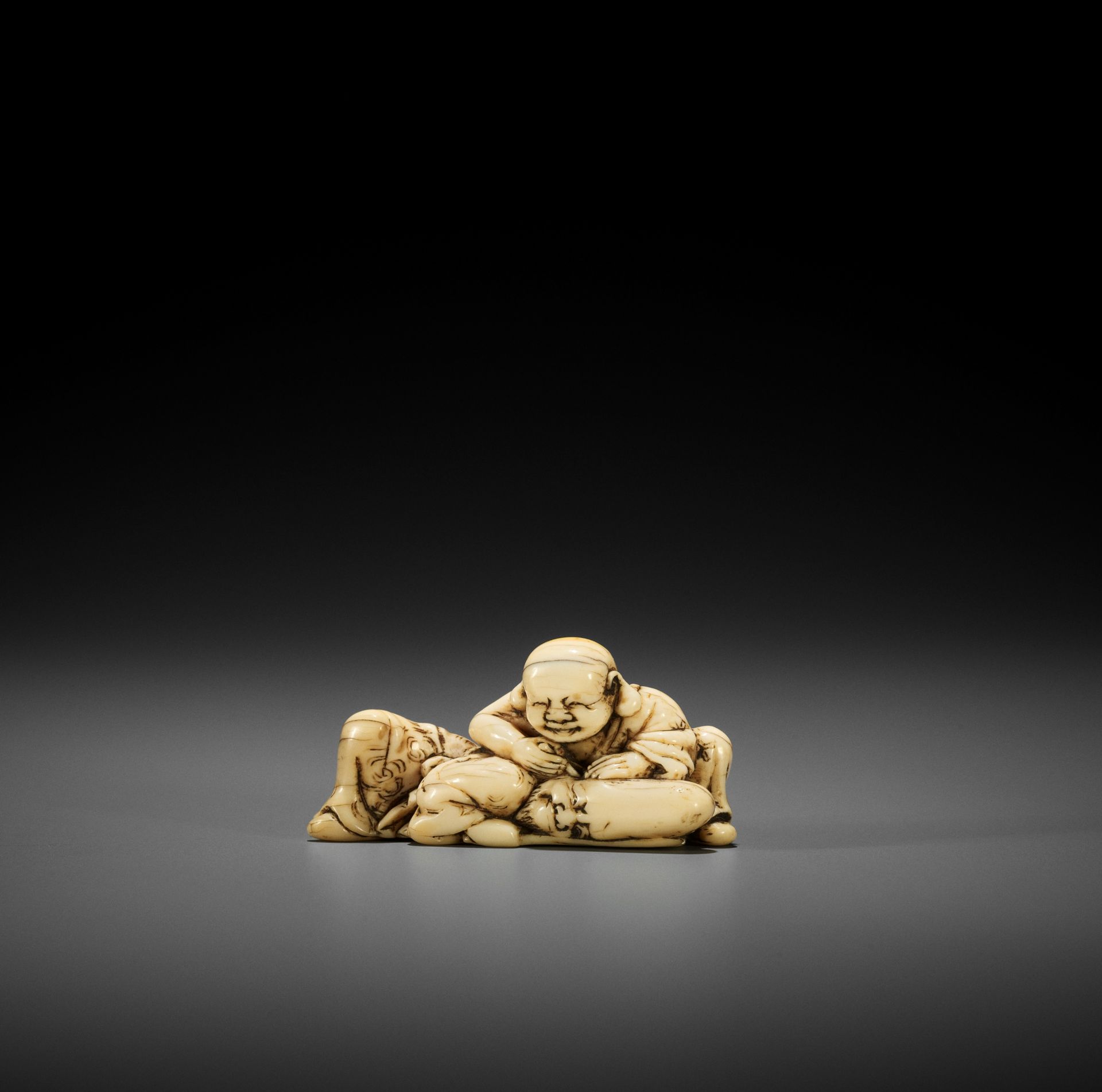 AN EARLY IVORY NETSUKE OF HOTEI AND FUKUROKUJU