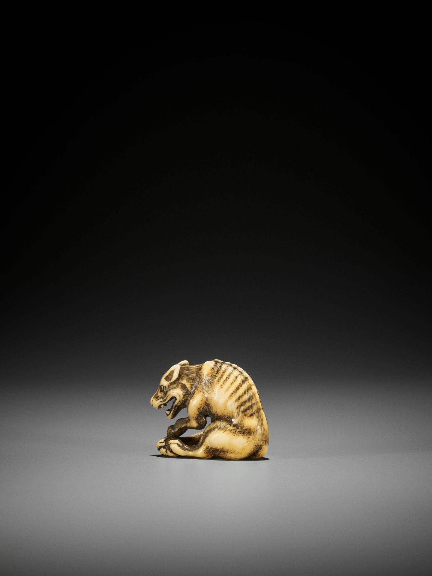 TOMOTADA: A FINE IVORY NETSUKE OF A WOLF WITH HAUNCH OF VENISON - Image 11 of 18