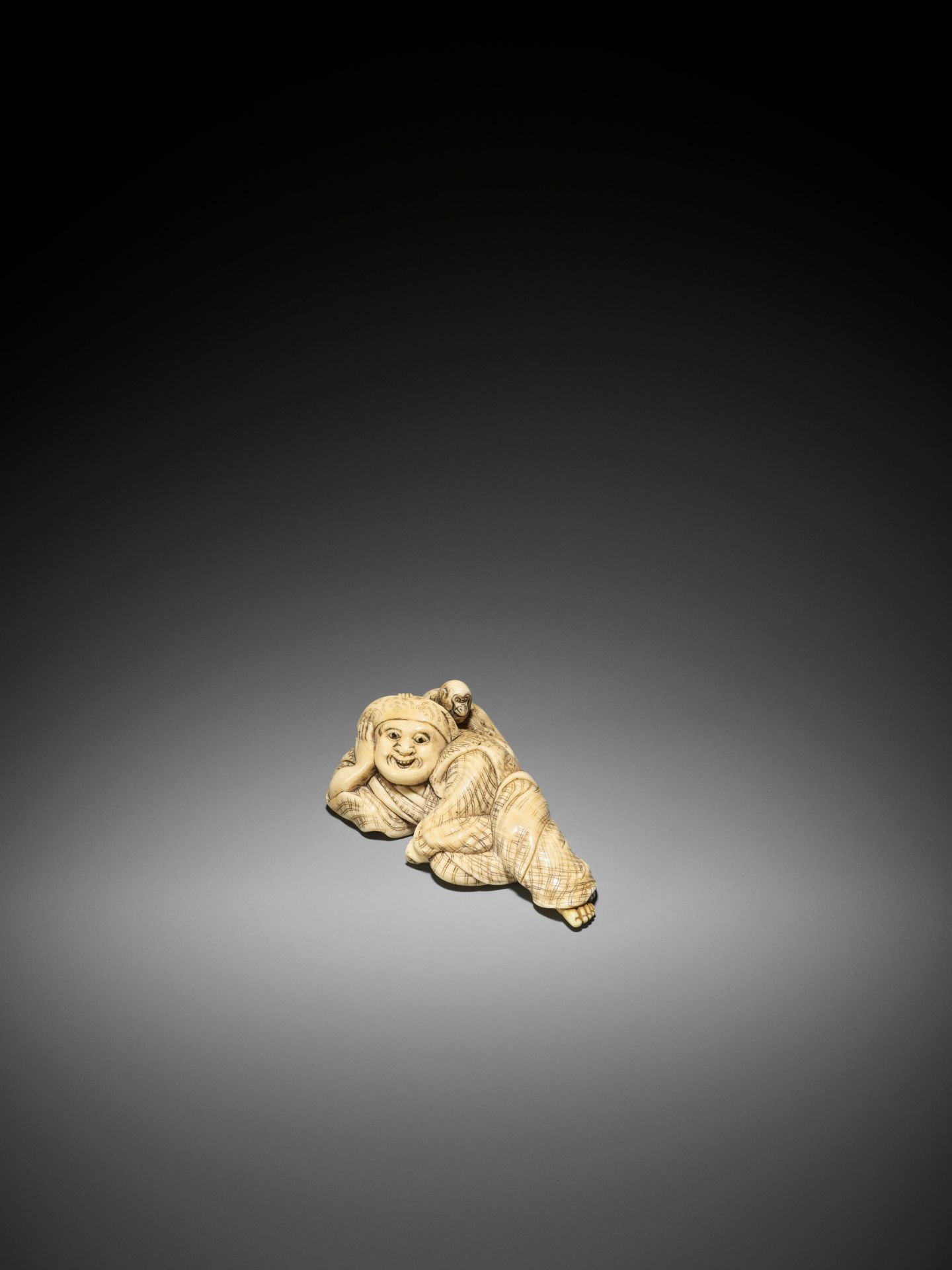 YOSHINAGA: A LARGE AND EXCEPTIONAL IVORY NETSUKE OF A RECLINING SARUMAWASHI WITH MONKEY - Image 4 of 9