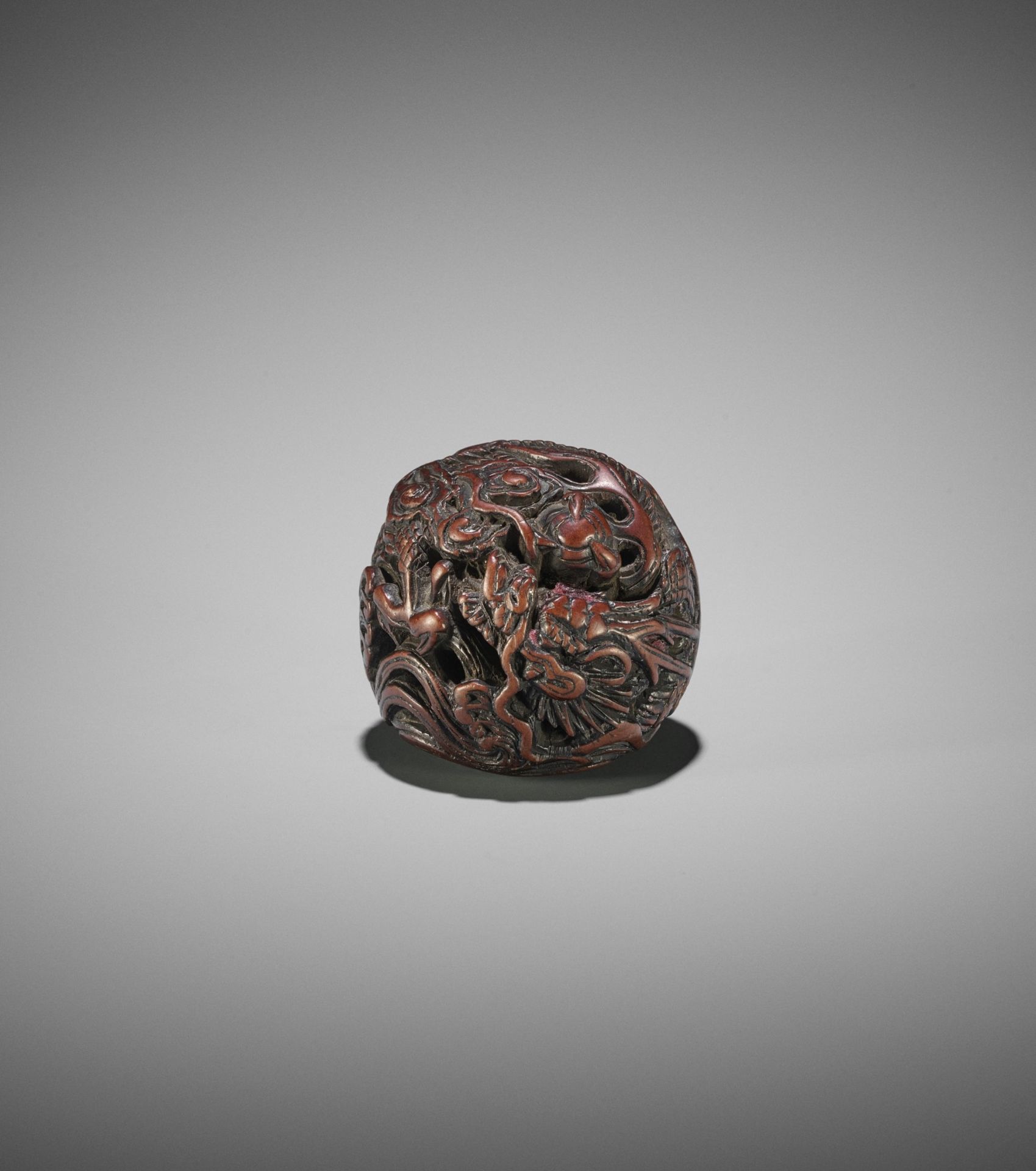 A POWERFUL WOOD NETSUKE OF A COILED DRAGON