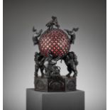 A RARE TEMPLE LAMP OF BRONZE SHISHI SUPPORTING A BROCADE BALL