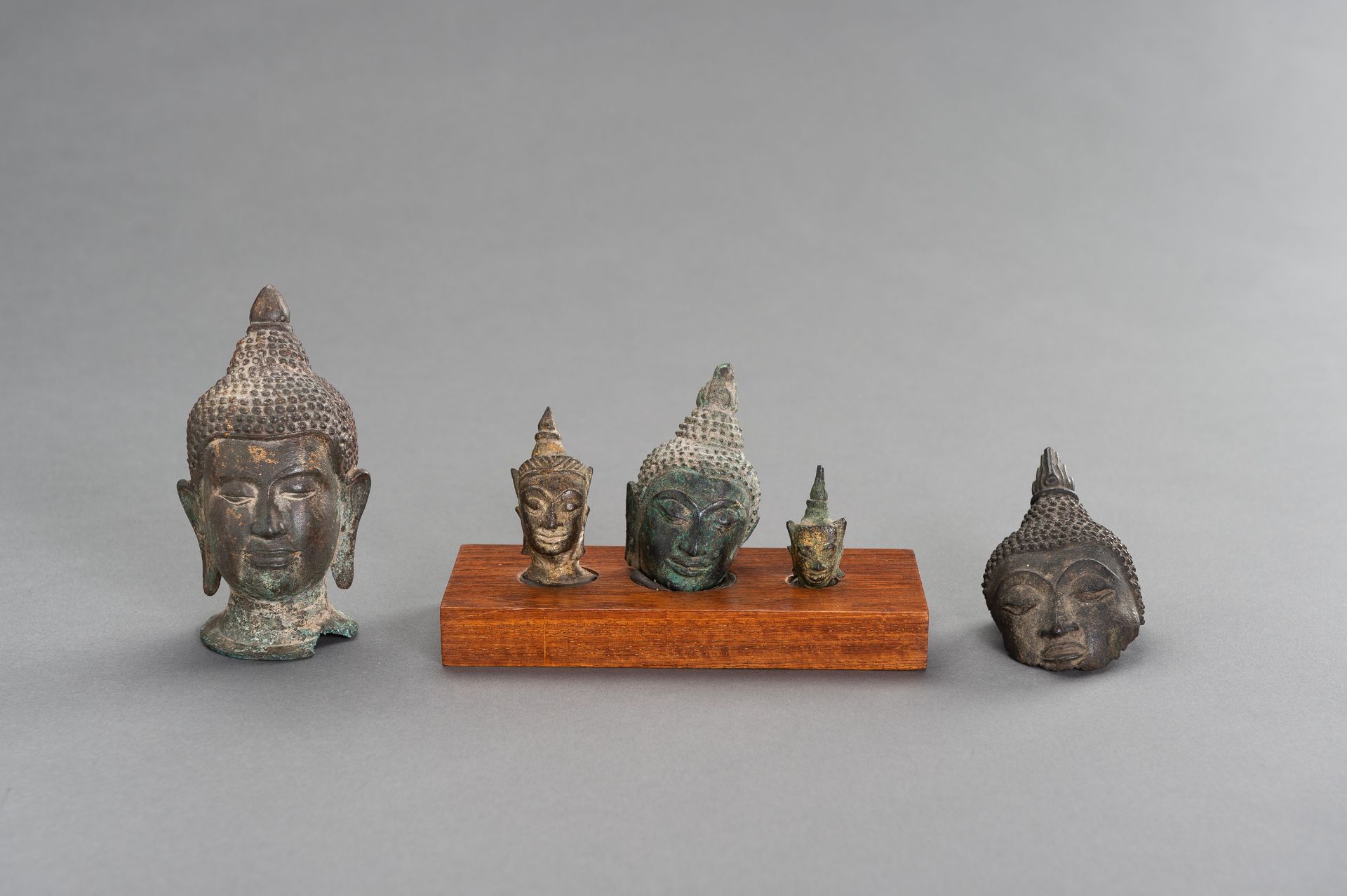 A LOT WITH FIVE SMALL BRONZE BUDDHA HEADS