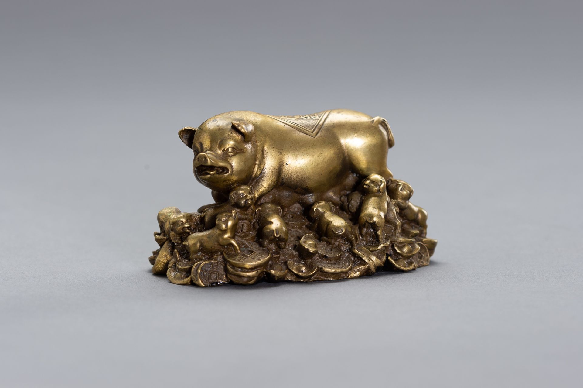 A BRONZE LUCKY CHARM OF A SOW WITH HER YOUNG