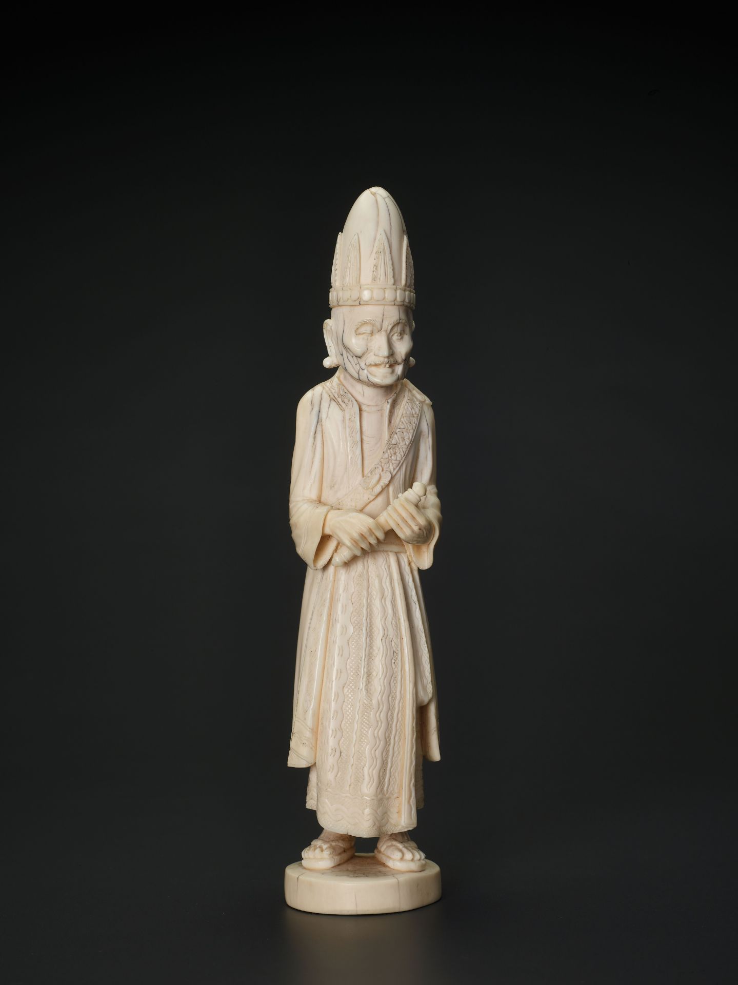 A 19TH CENTURY INDO-PERSIAN IVORY SCULPTURE OF A PRIEST