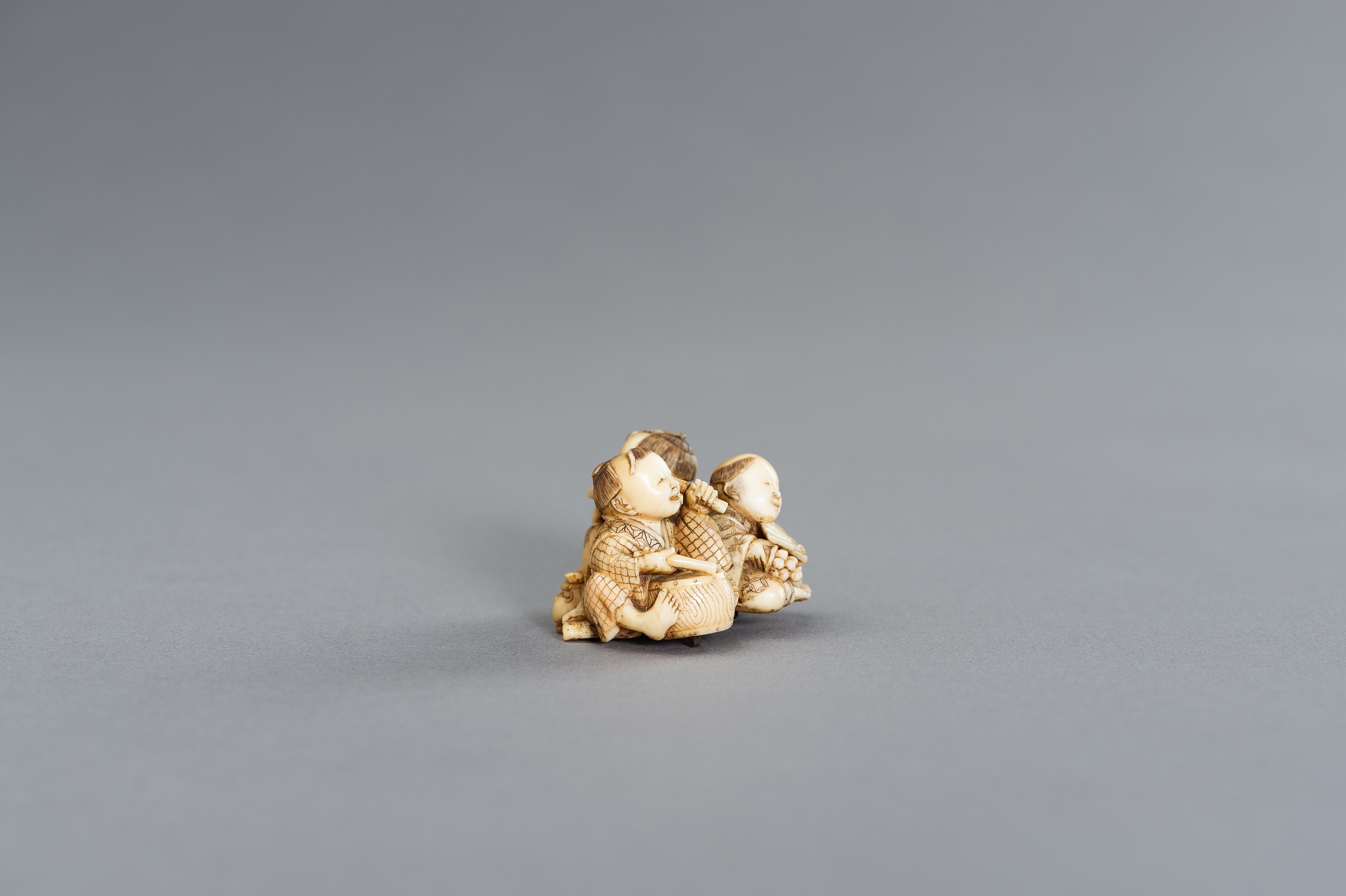 AN IVORY NETSUKE OKIMONO OF THREE BOYS AS MUSICIANS - Image 5 of 11