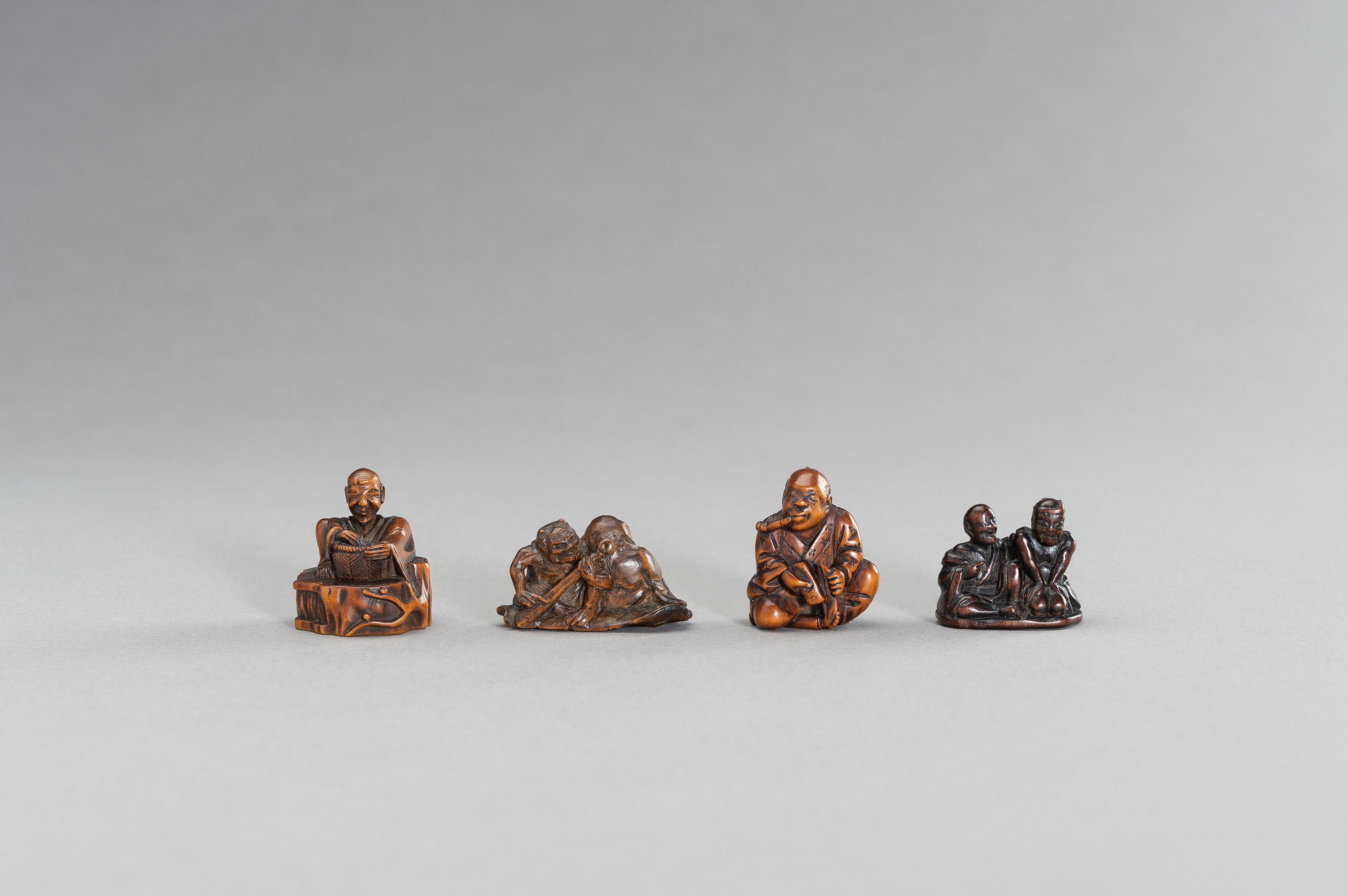 A GROUP OF FOUR FIGURAL WOOD NETSUKE