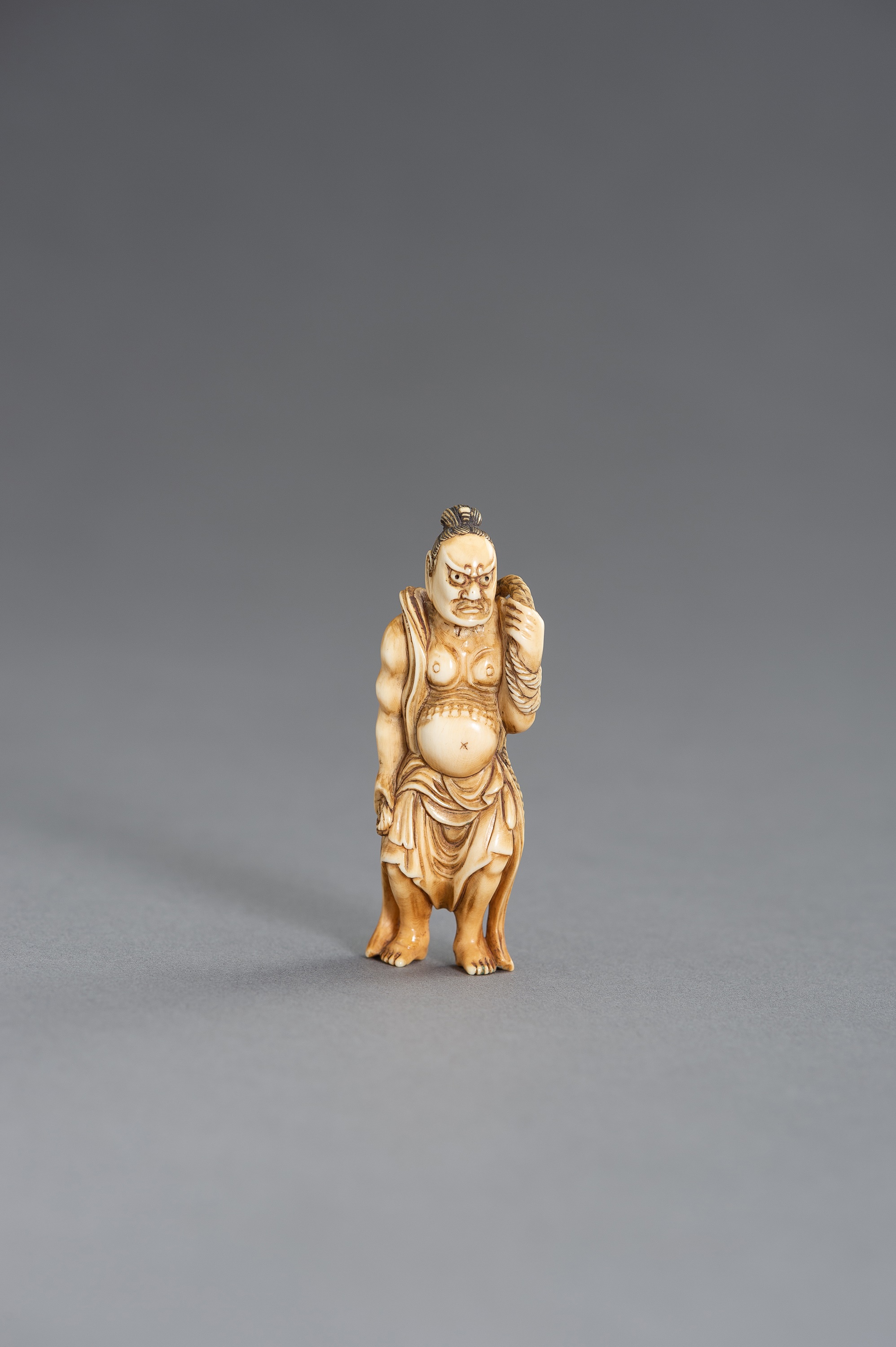 TOMOCHIKA: AN IVORY NETSUKE OF A NIO GUARDIAN WITH WARAJI - Image 3 of 3