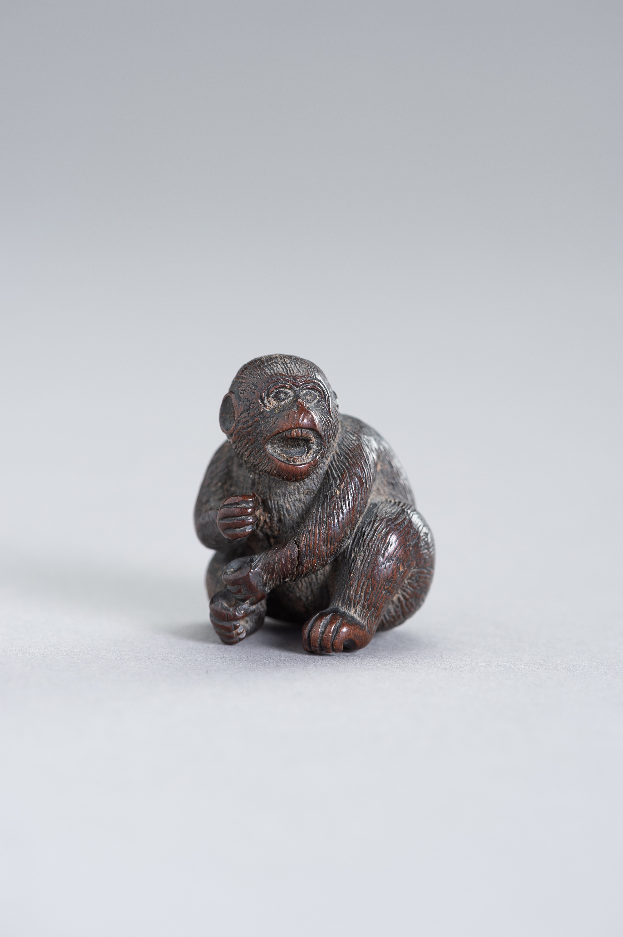 A NAGOYA SCHOOL WOOD NETSUKE OF A MONKEY