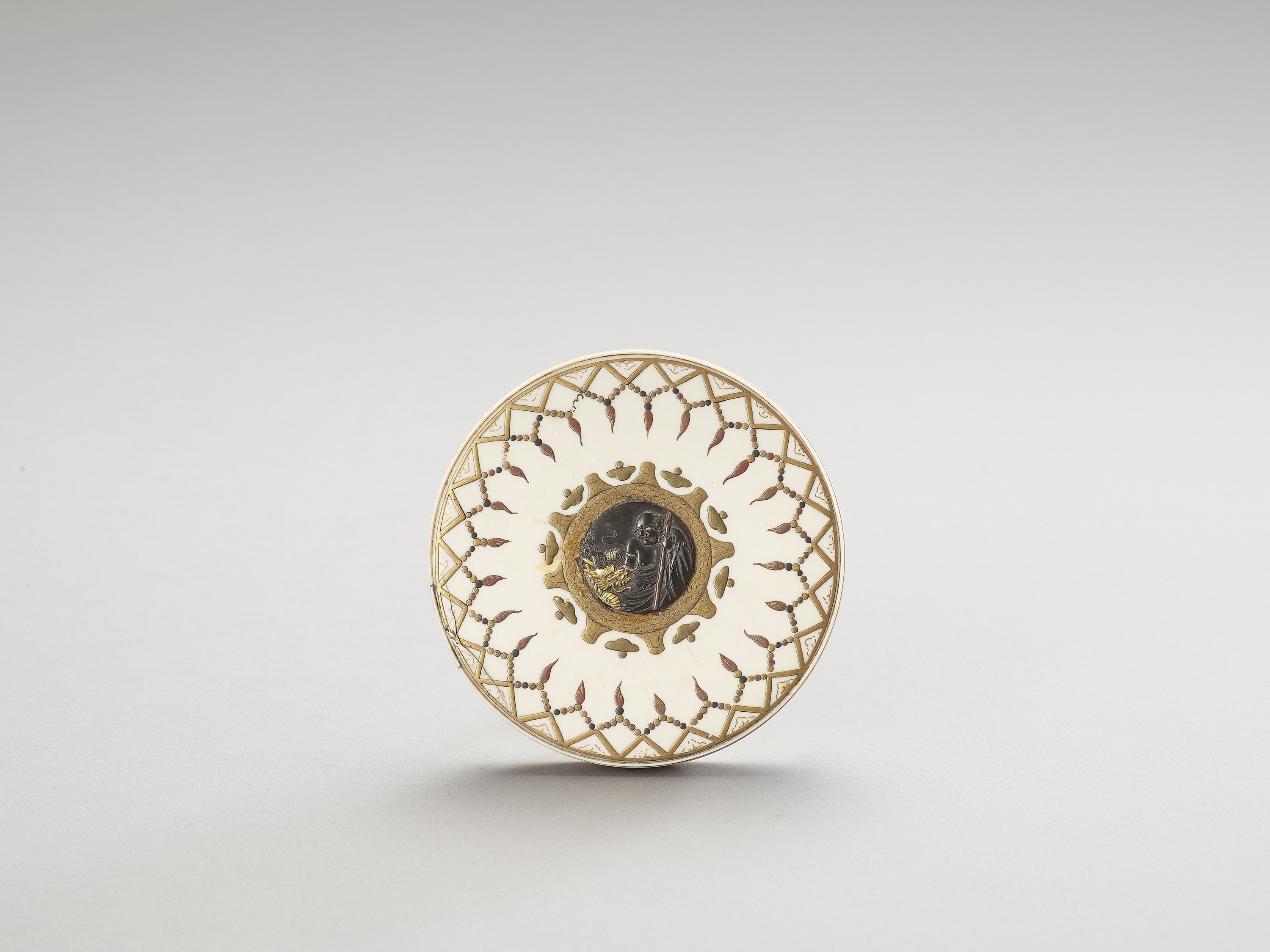 AN IVORY, METAL AND LACQUERED CIRCULAR LIDDED BOX