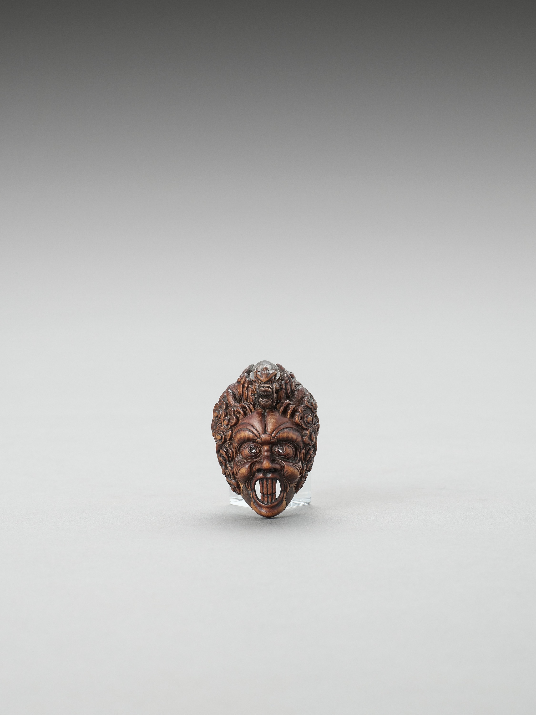 A WOOD BUGAKU MASK NETSUKE OF RANRYO-O