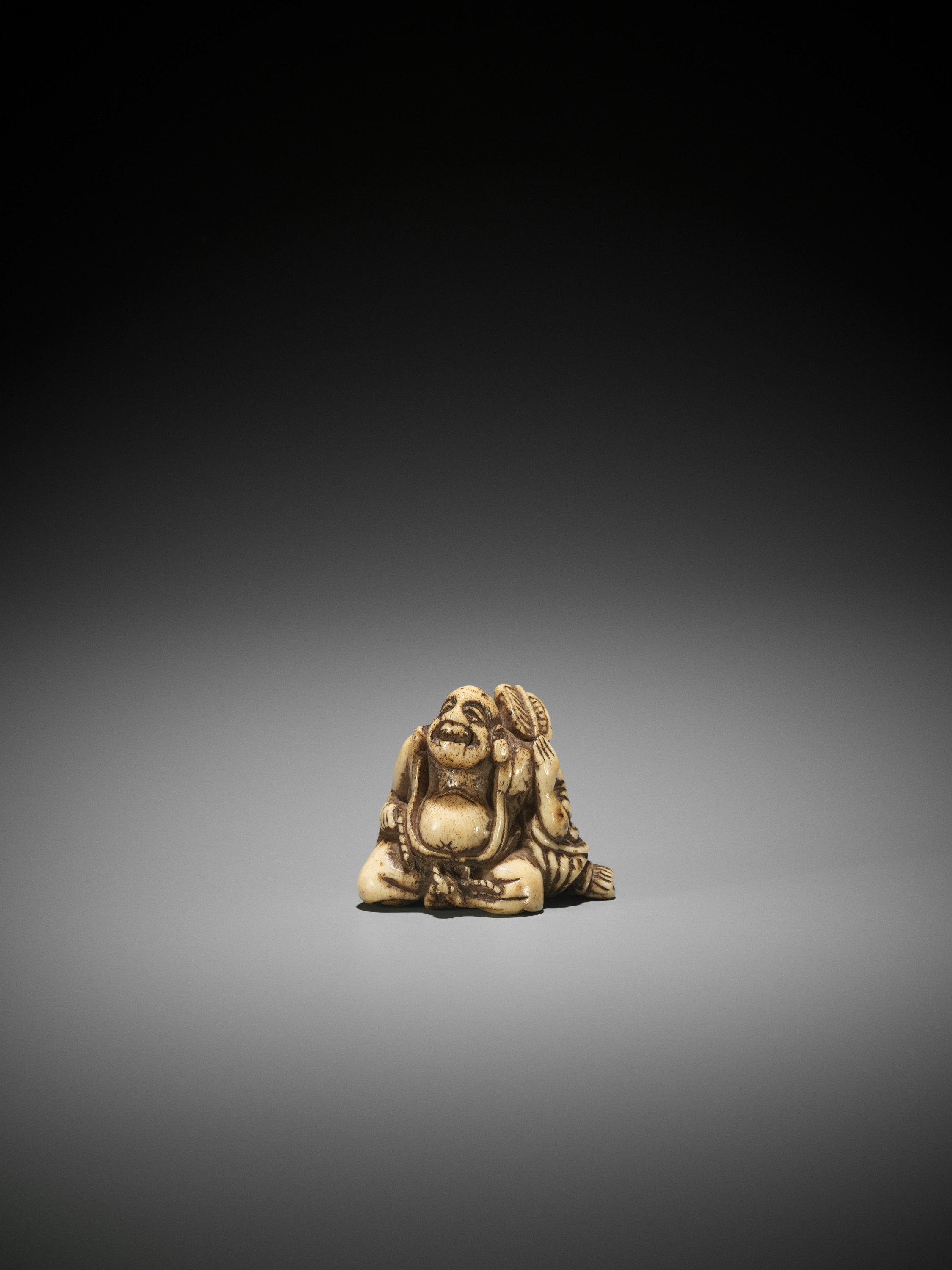 A STAG ANTLER NETSUKE OF HOTEI