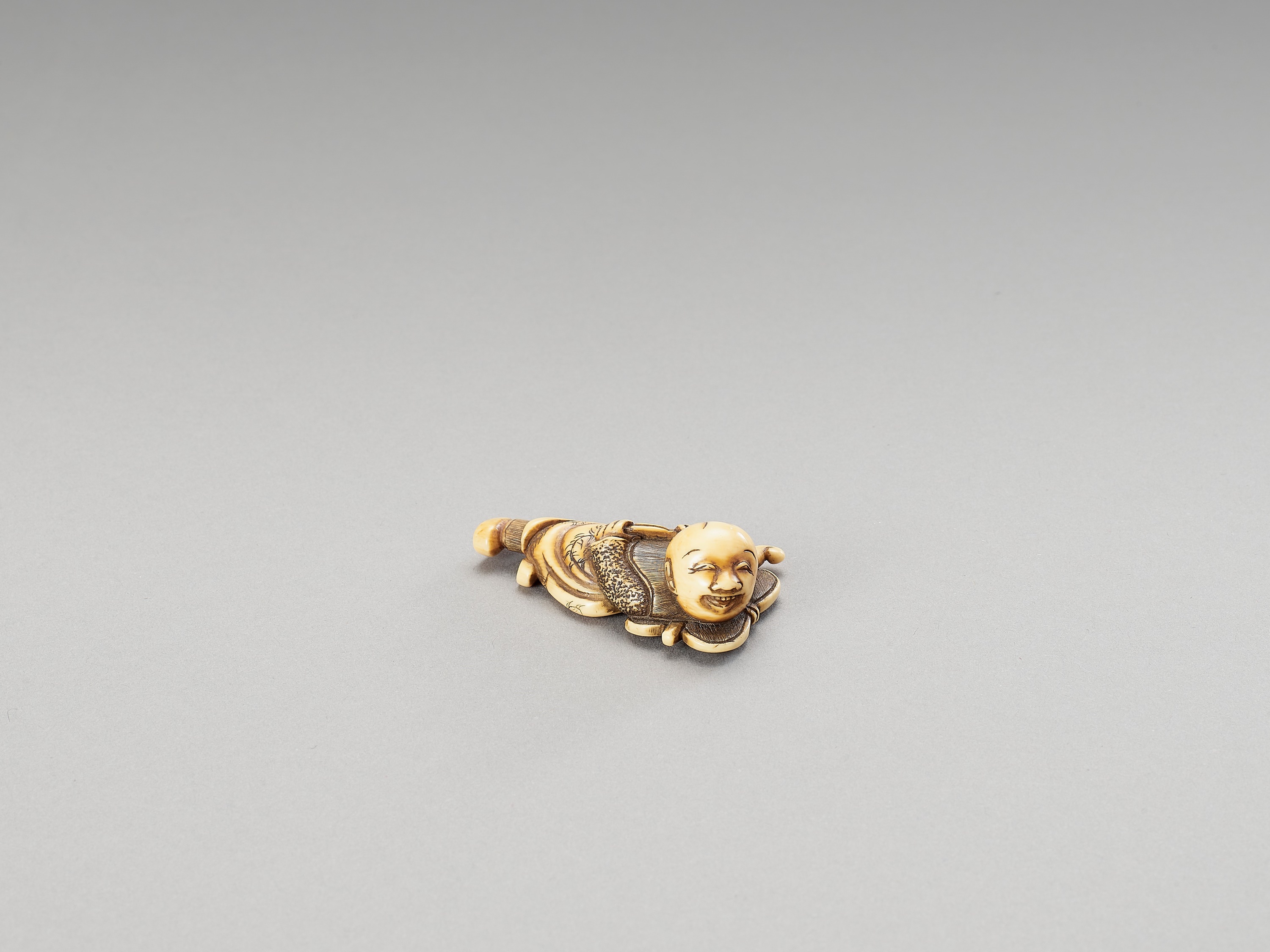 A HIDEMASA-SCHOOL IVORY NETSUKE OF A KARAKO ON A FAN - Image 2 of 3