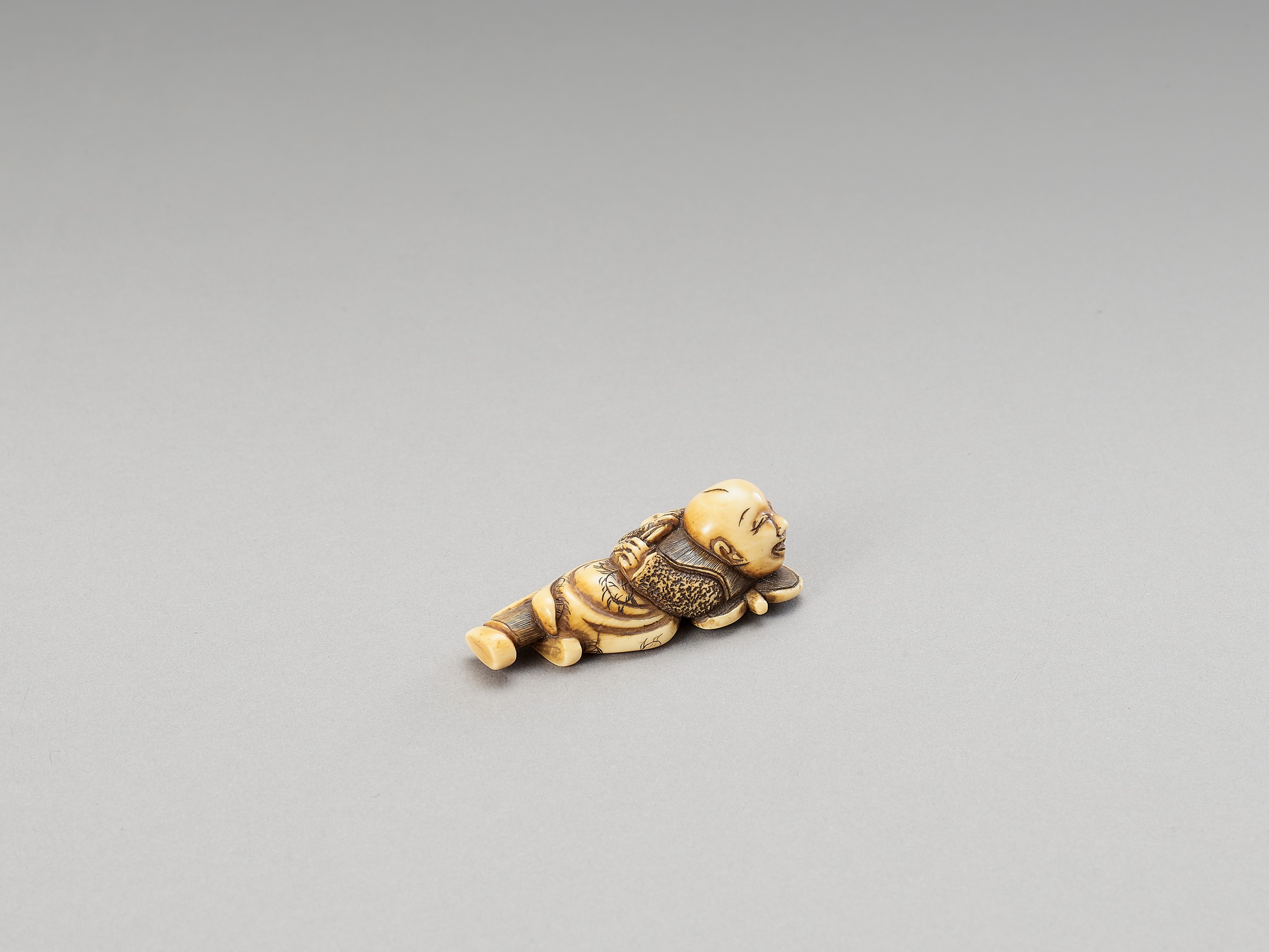 A HIDEMASA-SCHOOL IVORY NETSUKE OF A KARAKO ON A FAN - Image 3 of 3