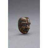 A BRONZE SCROLL WEIGHT IN THE SHAPE OF A NOH MASK