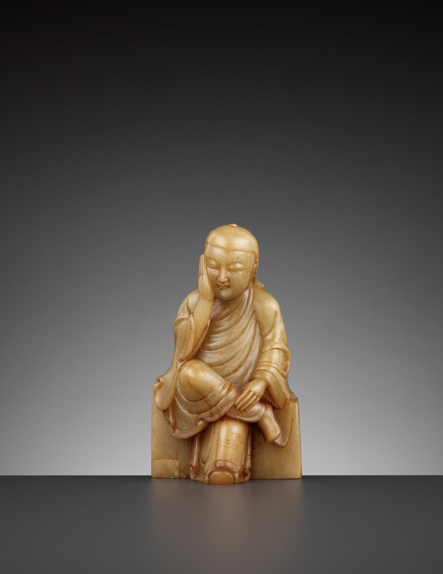 A SOAPSTONE FIGURE OF A PENSIVE IMMORTAL, QING DYNASTY