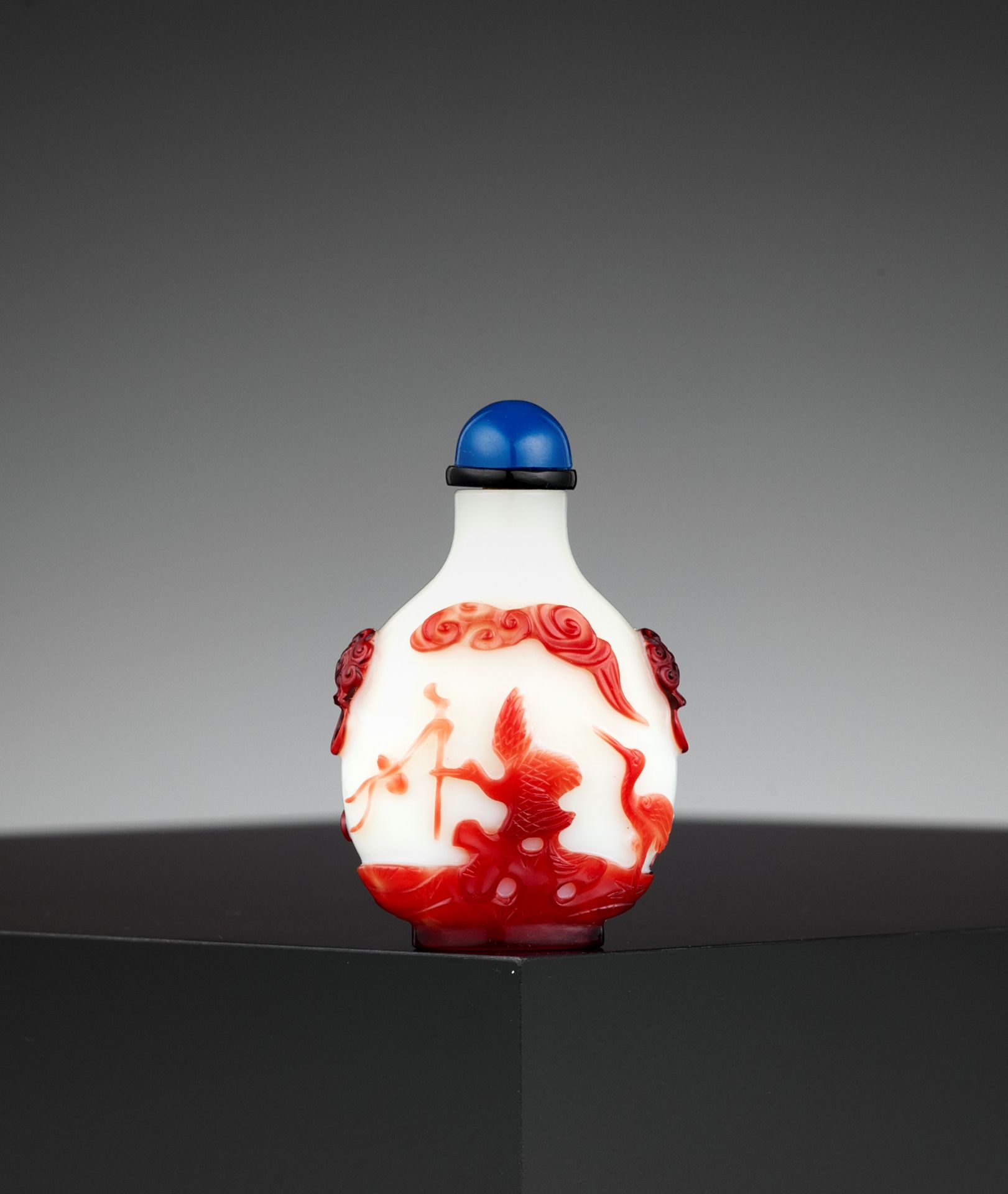 A RUBY-RED OVERLAY 'AUSPICIOUS' WHITE GLASS SNUFF BOTTLE, QING DYNASTY