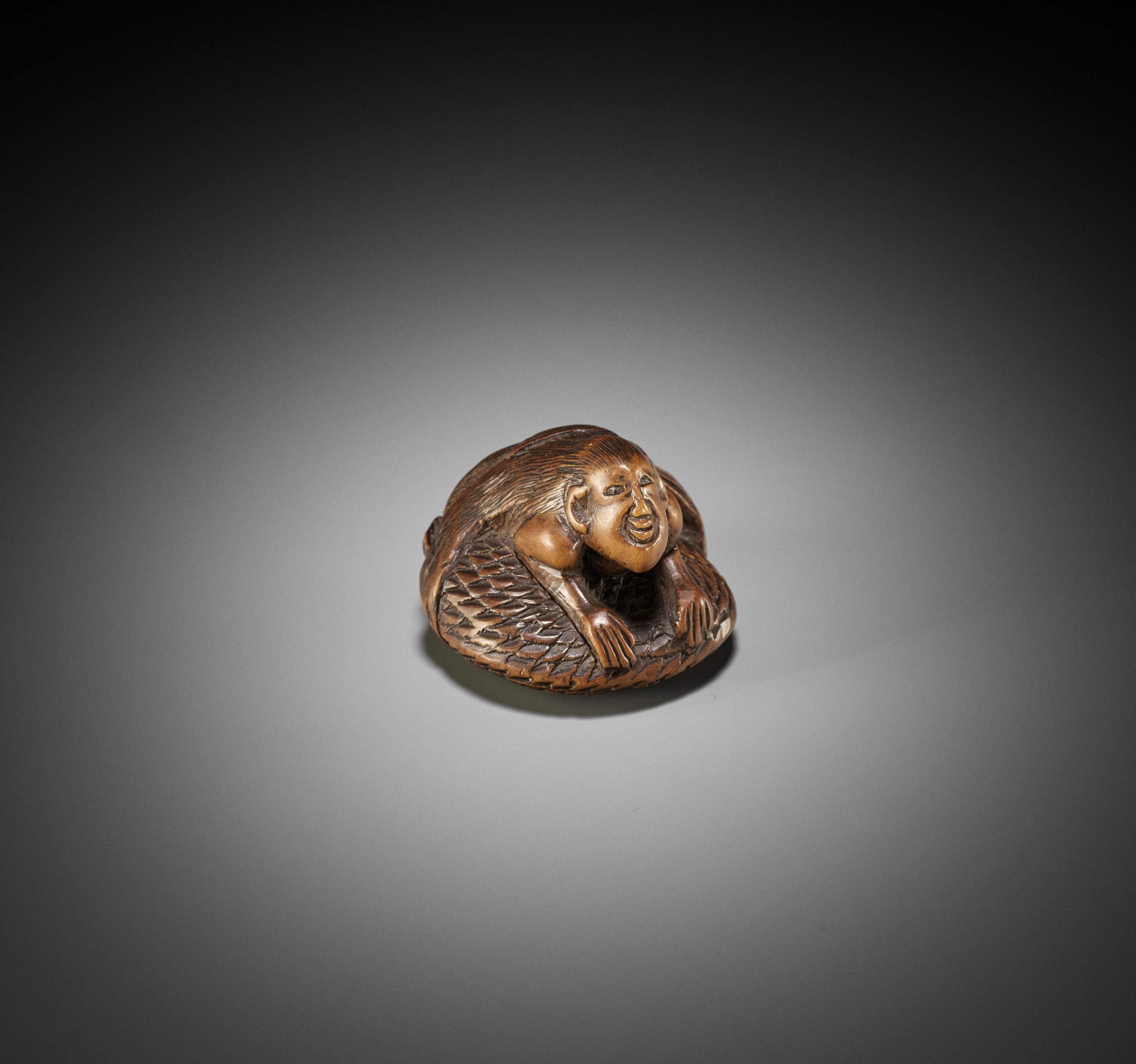 A RARE WOOD NETSUKE OF A NINGYO (MERMAID)