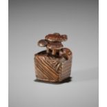 MASANAO: A RARE WOOD NETSUKE OF A SNAIL AND THREE REISHI ON A WELL BUCKET