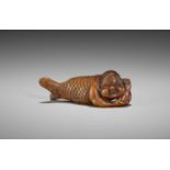 SHUGETSU: A RARE WOOD NETSUKE OF OKAME AS A MERMAID (NINGYO)