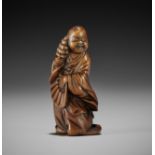 A SUPERB WOOD NETSUKE OF A DANCING OKAME