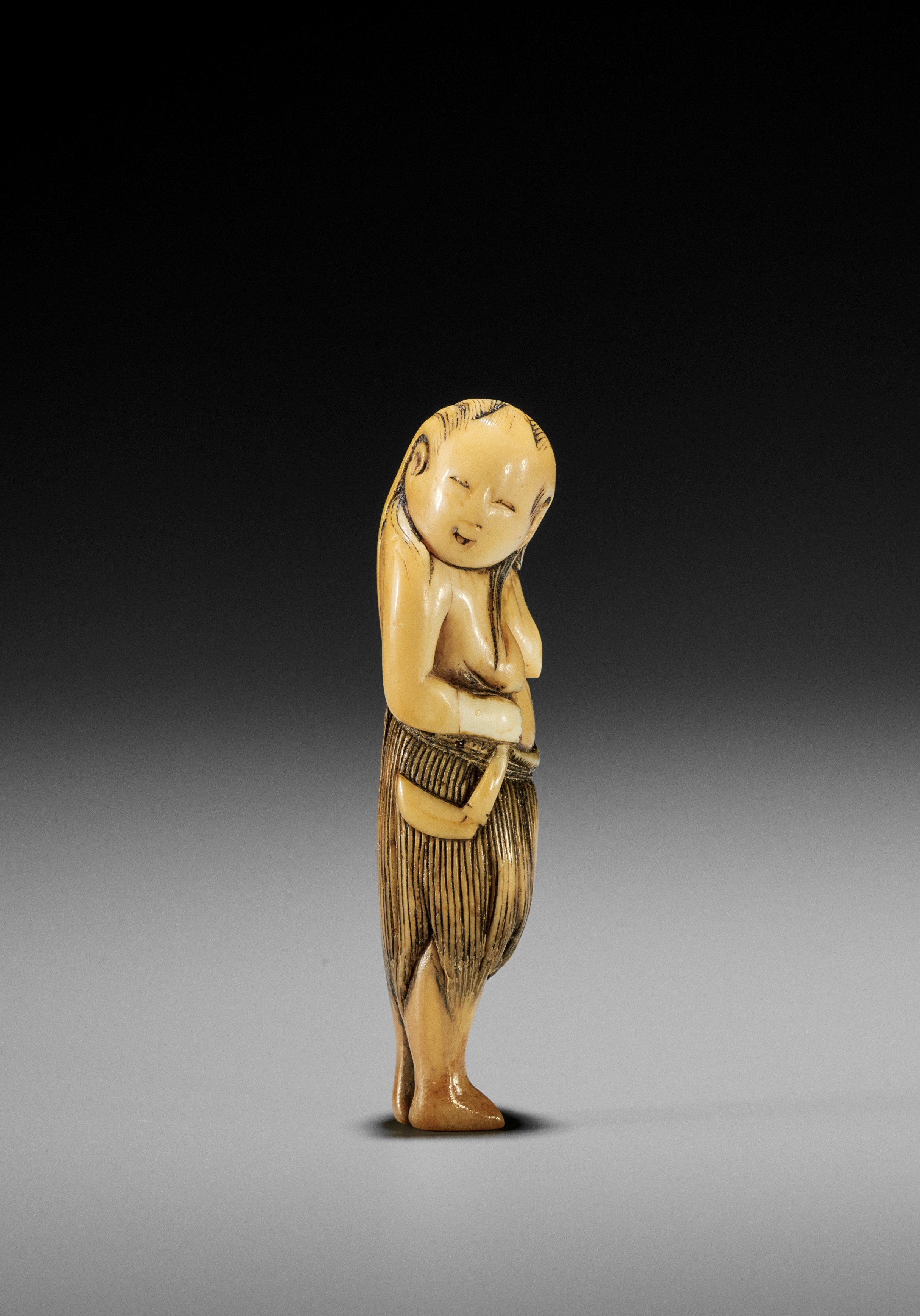 AN IVORY NETSUKE OF A FISHERGIRL (AMA)