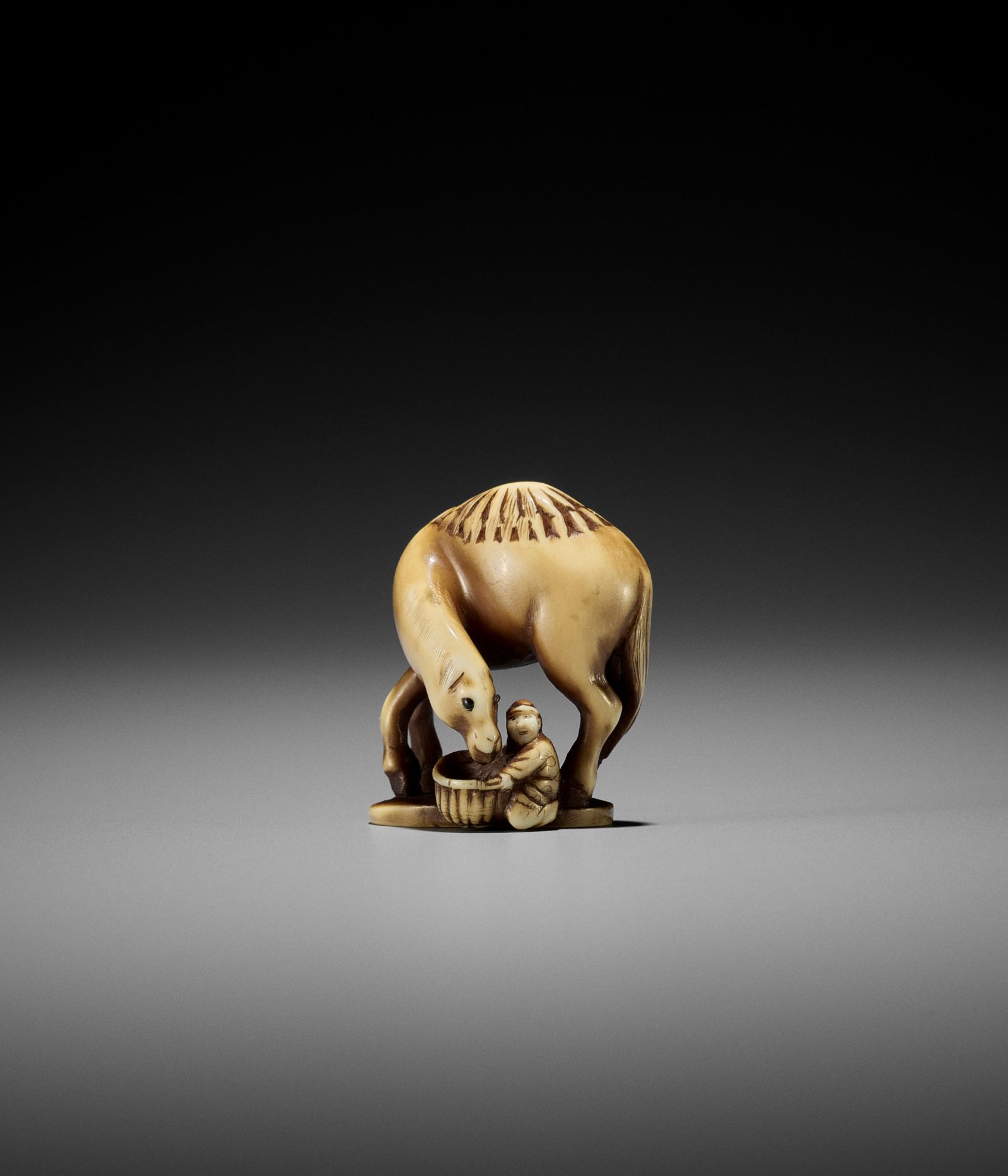 RANTEI: A RARE IVORY NETSUKE OF A DUTCHMAN FEEDING A DROMEDARY