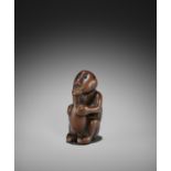 A RARE AND UNUSUAL NETSUKE OF AN ISLANDER DRINKING FROM A BOTTLE