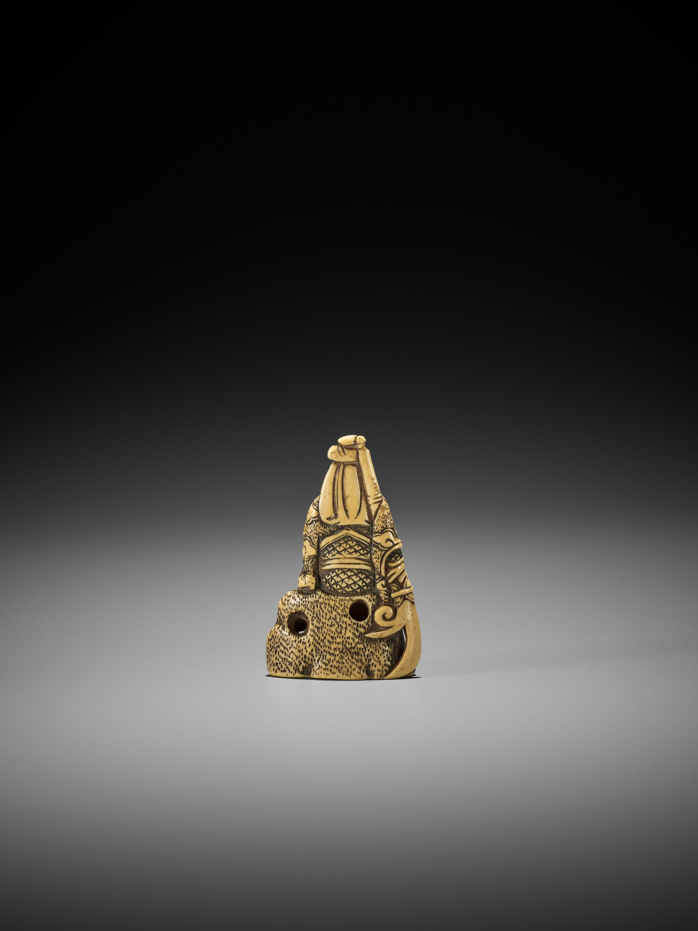 AN IVORY NETSUKE OF KAN'U LEANING AGAINST A ROCK - Image 3 of 8