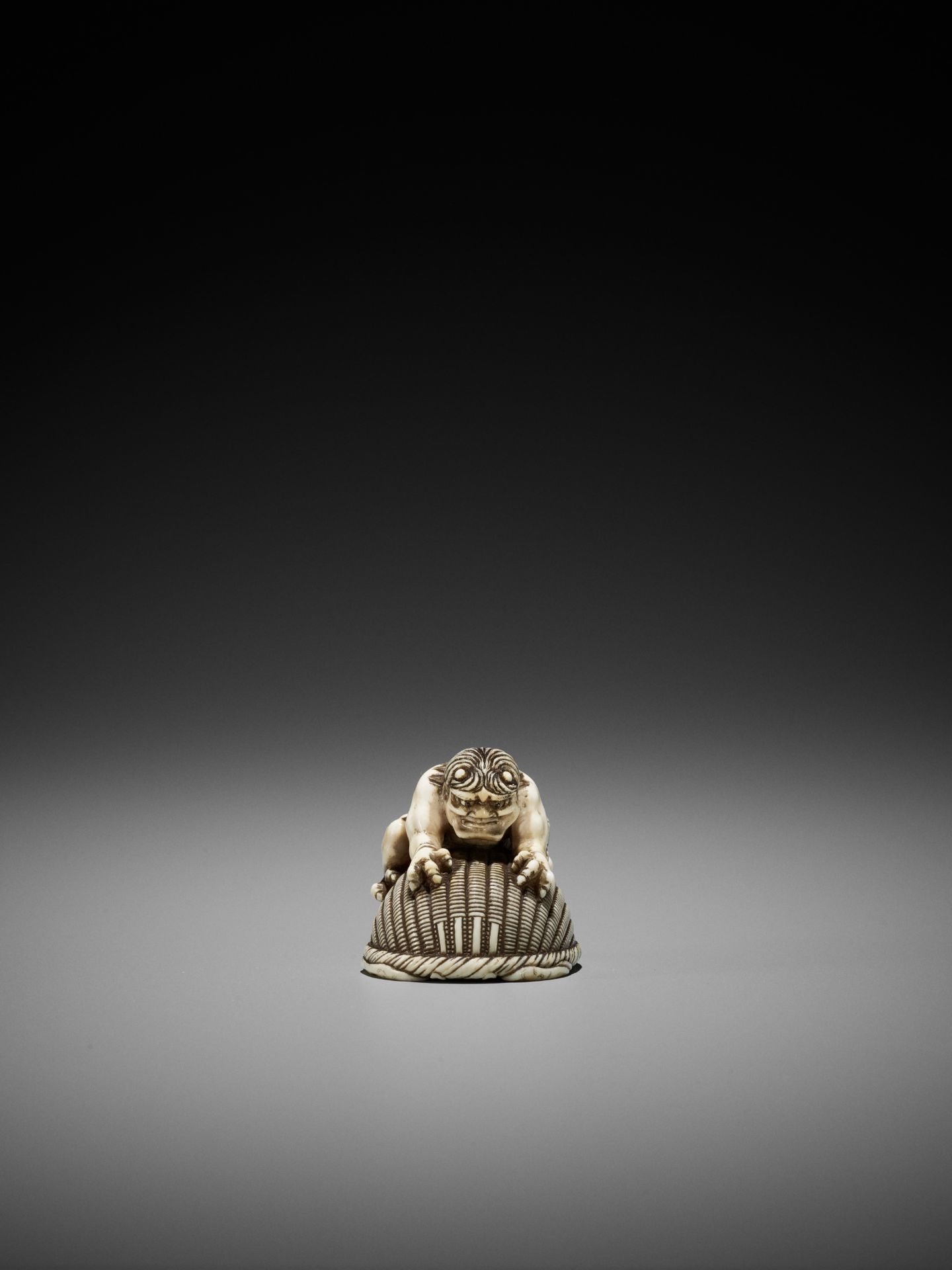 OKATORI: AN IVORY NETSUKE OF AN ONI TRAPPING SHOKI - Image 3 of 12