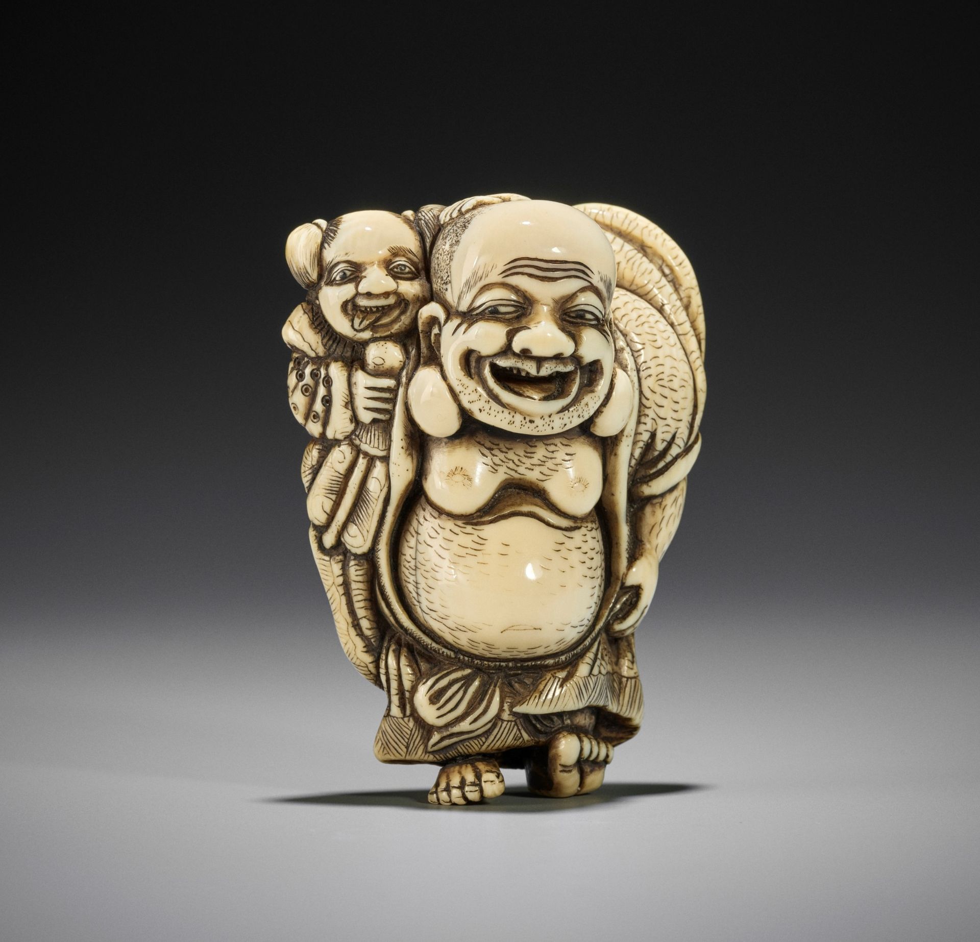 TOZAN: A SUPERB AND LARGE IVORY NETSUKE OF HOTEI WITH KARAKO