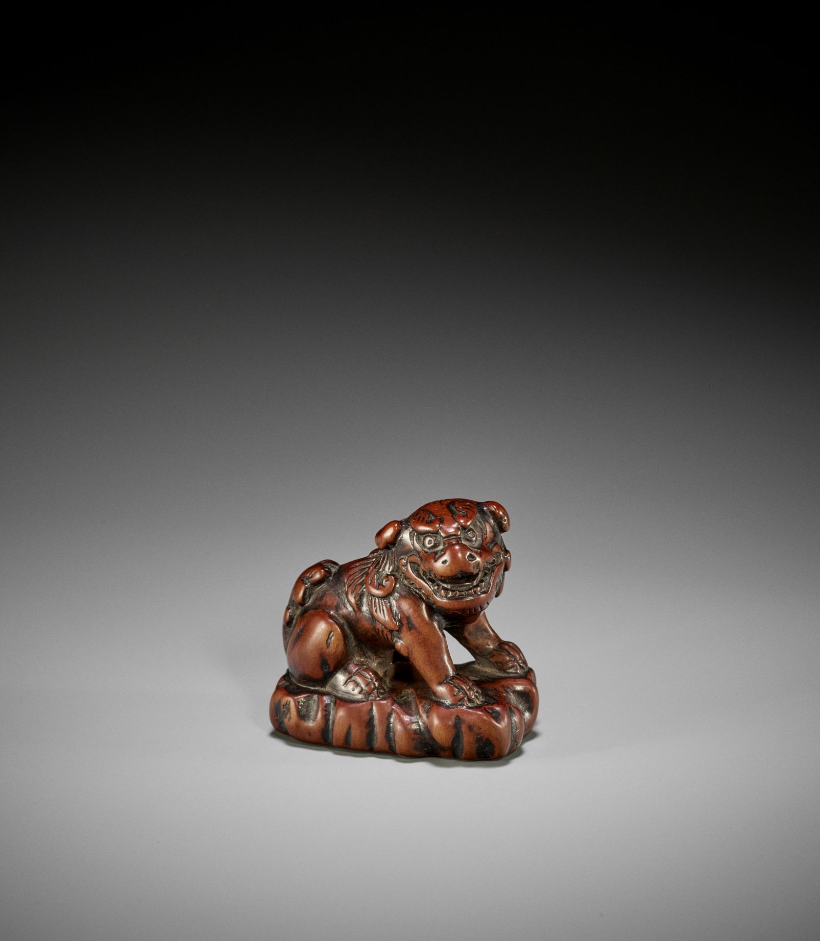 A GOOD WOOD NETSUKE OF A SHISHI