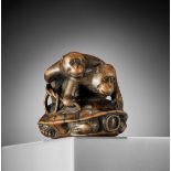 SHUZAN: A WOOD NETSUKE OF TWO MONKEYS MOUNTING A TORTOISE