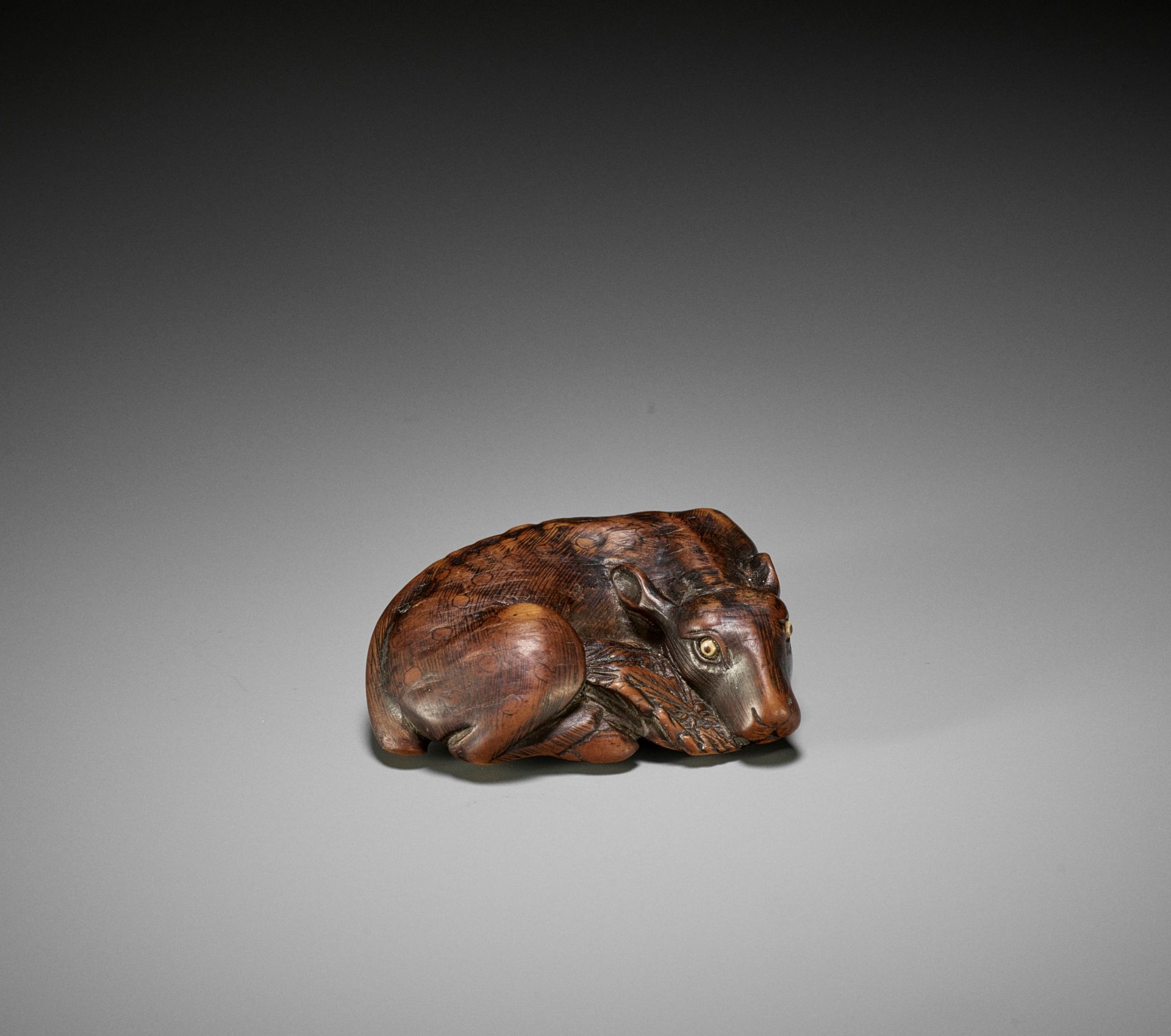 MASATOMO: A FINE WOOD NETSUKE OF A RECUMBENT DEER