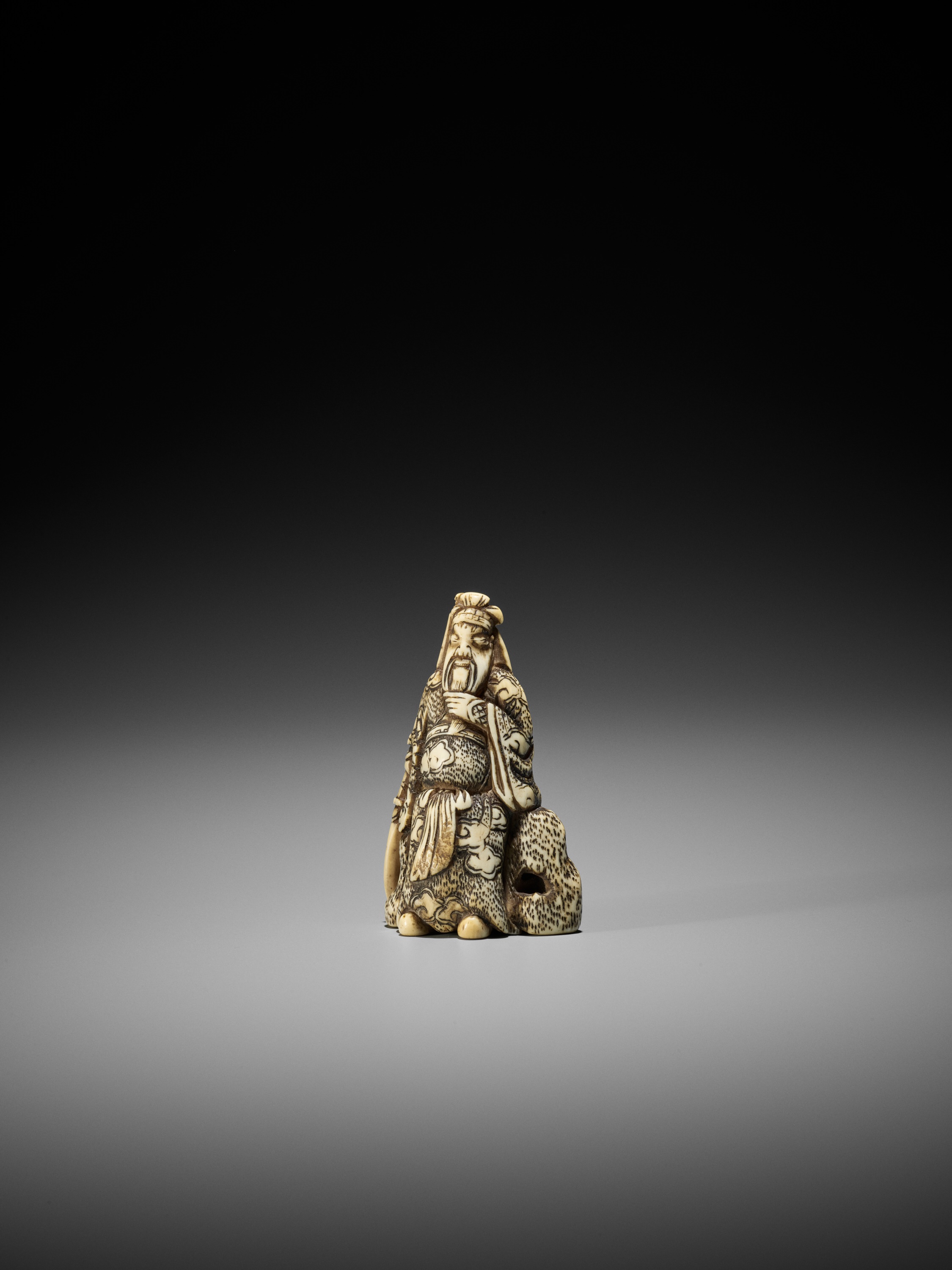 AN IVORY NETSUKE OF KAN'U LEANING AGAINST A ROCK - Image 5 of 8