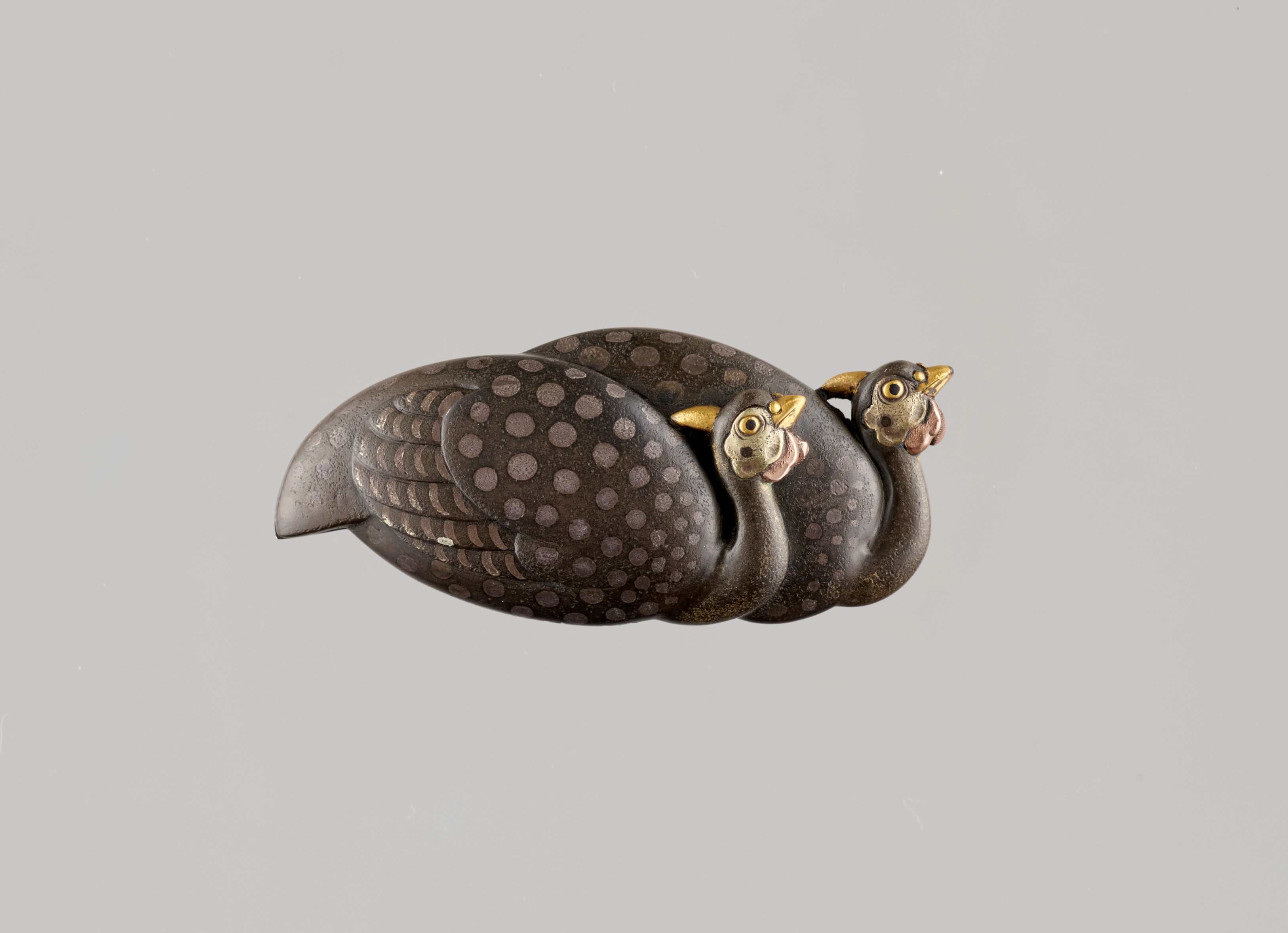 KATSUAKI: A FINE SILVER-MOUNTED OBIDOME (SASH CLIP) DEPICTING PHEASANTS